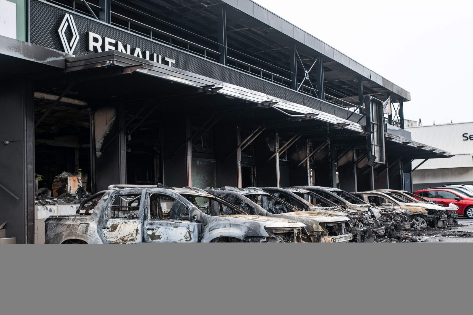 This photograph shows burnt cars of the Renault Dacia parking lot in the Magenta district of Noumea, France's Pacific territory of New Caledonia, on May 17, 2024. France deployed troops to New Caledonia's ports and international airport, banned TikTok and imposed a state of emergency on May 16 after three nights of clashes that have left four dead and hundreds wounded. Pro-independence, largely indigenous protests against a French plan to impose new voting rules on its Pacific archipelago have spiralled into the deadliest violence since the 1980s, with a police officer among several killed by gunfire. (Photo by Delphine Mayeur / AFP)