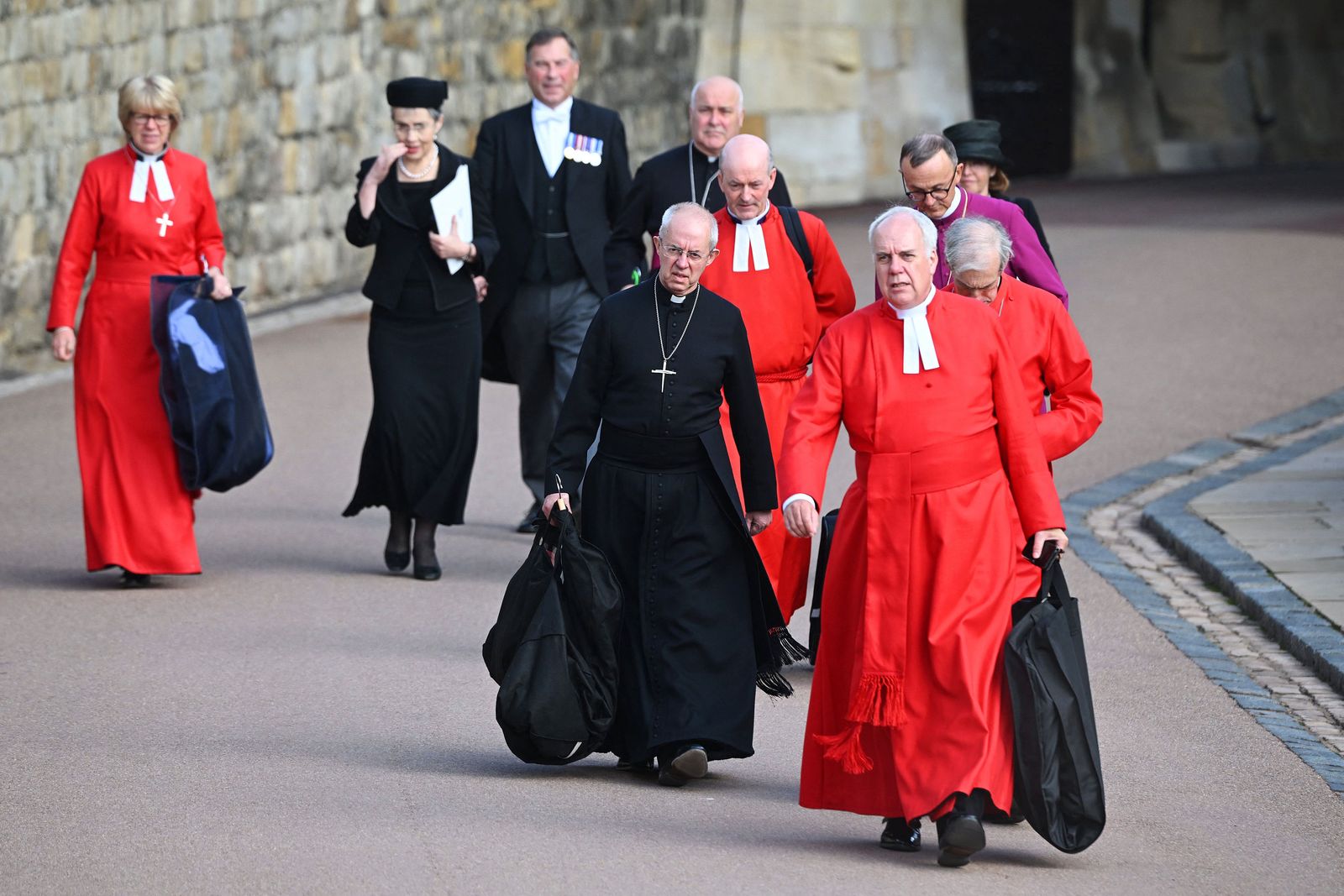 رئيس أساقفة كانتربري جاستين ويلبي وأعضاء آخرين من رجال كنيسة يغادرون بعد انتهاء مراسم جنازة الملكة إليزابيث الثانية في لندن - AFP
