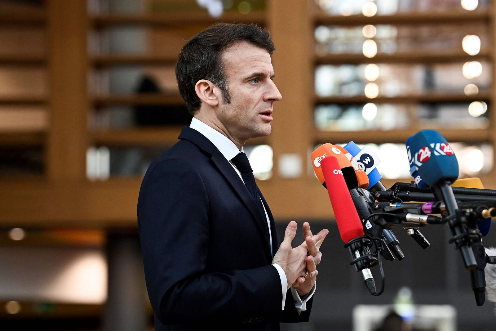 France's President Emmanuel Macron answers journalists' questions as he arrives for a summit at EU parliament in Brussels, on February 9, 2023. - Ukraine's President is set to attend an EU summit in Brussels on February 9, 2023, as the guest of honour where he will press allies to deliver fighter jets 