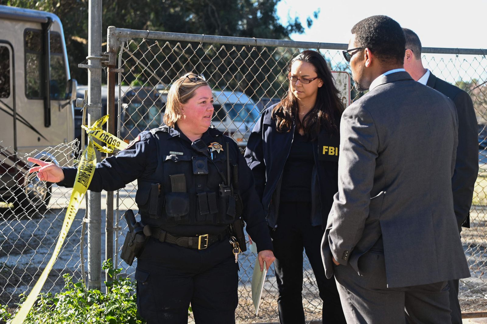 A San Mateo County Sheriff deputy (L) lspeaks with FBI agents before they enter to investigate crime scene after shooting at the Spanish Town shops in Half Moon Bay, California, January 24, 2023. - An Asian farm worker was in custody January 23, 2023 after seven of his colleagues were killed in front of children at sites in California, days after a mass shooter killed 11 people at a Lunar New Year celebration near Los Angeles. The latest bloodshed to hit Asian Americans in California occurred at two farms around Half Moon Bay, a coastal community near San Francisco. (Photo by Samantha Laurey / AFP) - AFP