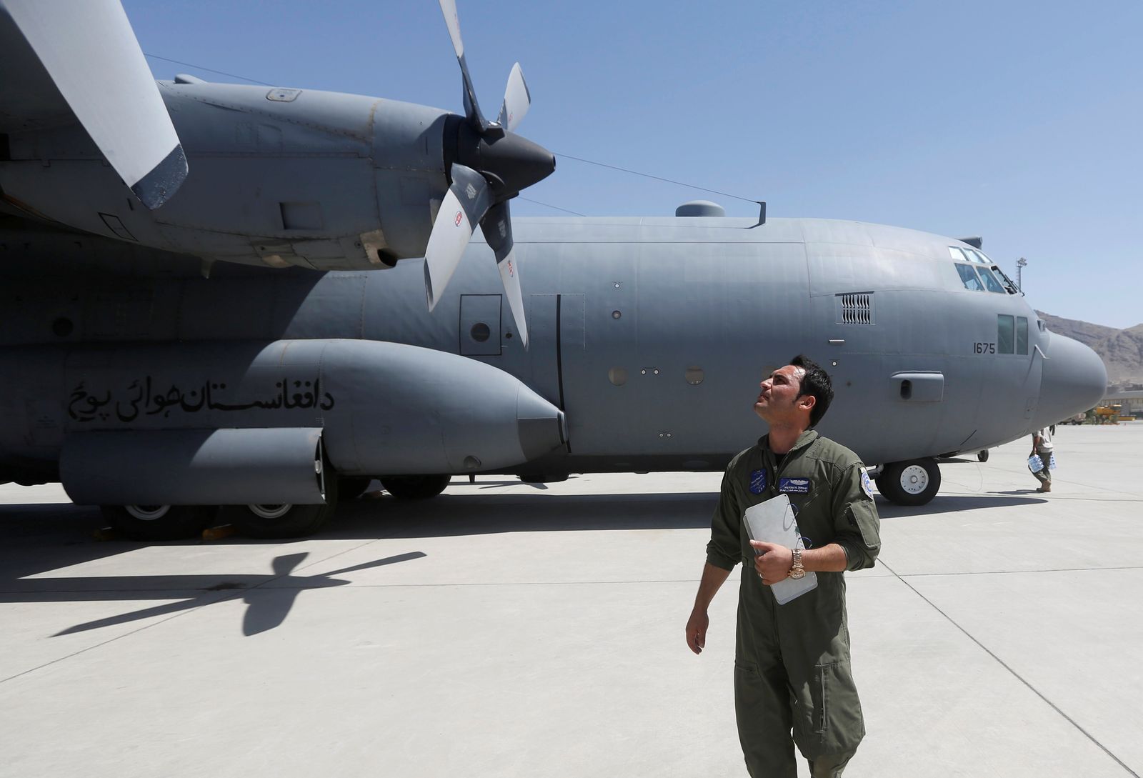 طيار أفغاني يفحص طائرة نقل عسكرية من طراز 