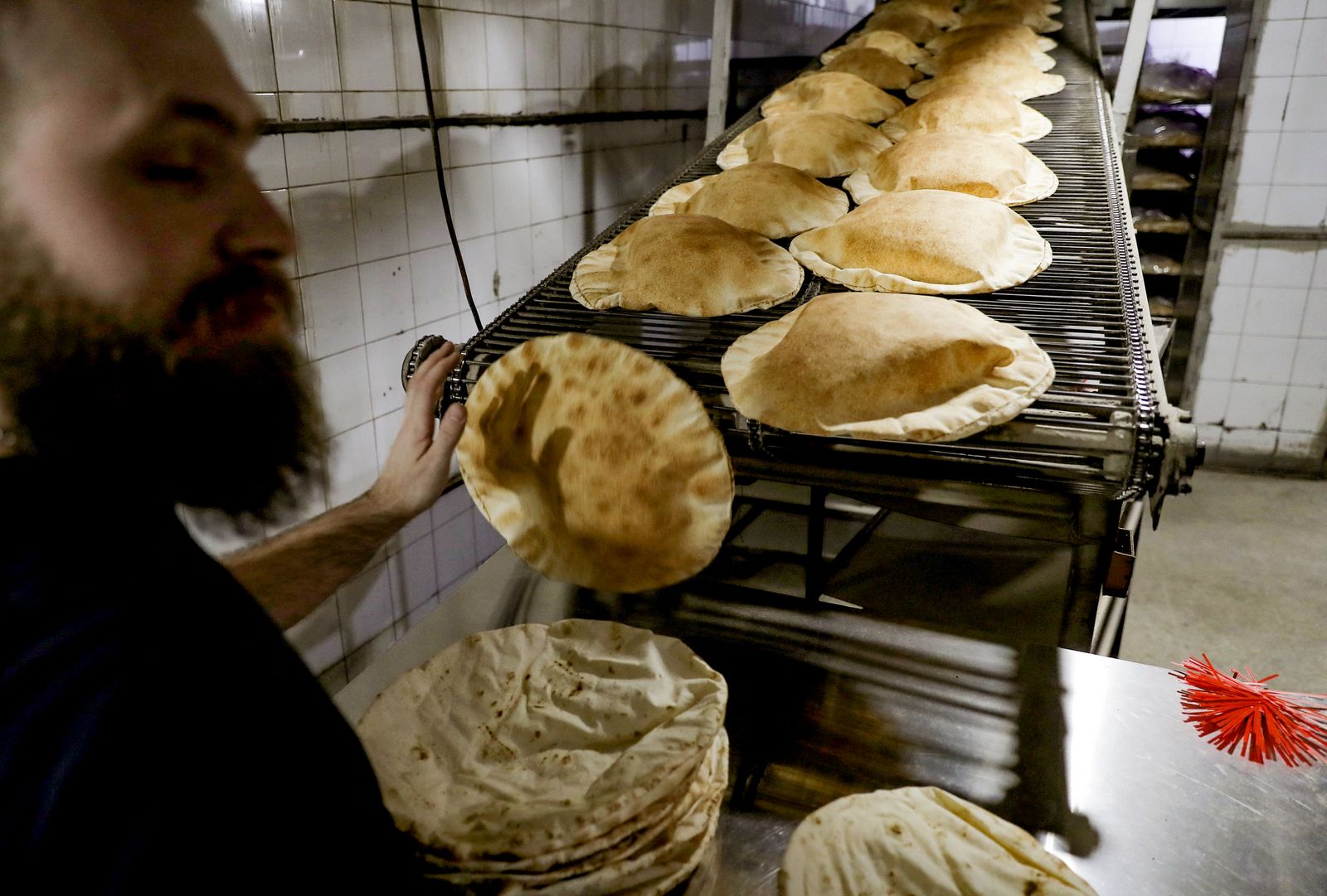 رجل يعمل في مخبز لإعداد الخبر المفرود التقليدي في العاصمة اللبنانية بيروت 26 فبراير 2021 - AFP
