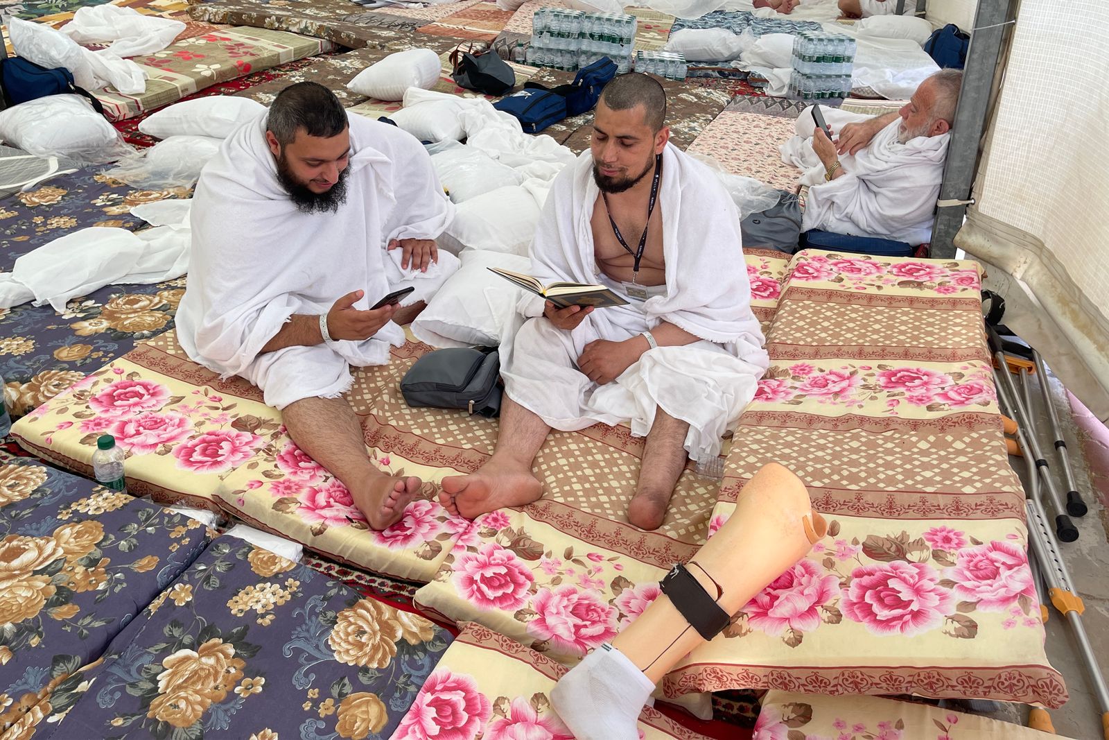 حجاج يقرأون القرآن في مشعر منى بمكة المكرمة، 26 يونيو 2023  - AFP