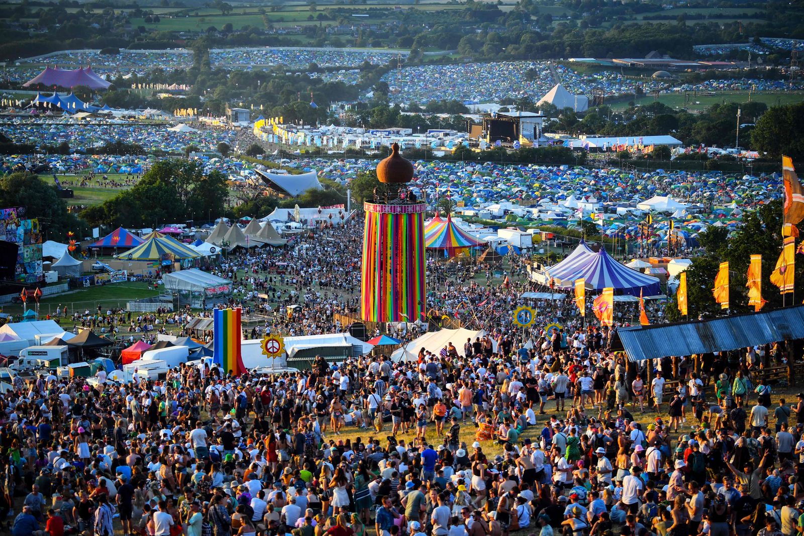 Festivalgoers attend the Glastonbury festival near the village of Pilton in Somerset, southwest England, on June 22, 2022. - More than 200,000 music fans and megastars Paul McCartney, Billie Eilish and Kendrick Lamar descend on the English countryside this week as Glastonbury Festival returns after a three-year hiatus. The coronavirus pandemic forced organisers to cancel the last two years' events, and those going this year face an arduous journey battling three days of major rail strikes across the country. (Photo by Andy Buchanan / AFP) - AFP