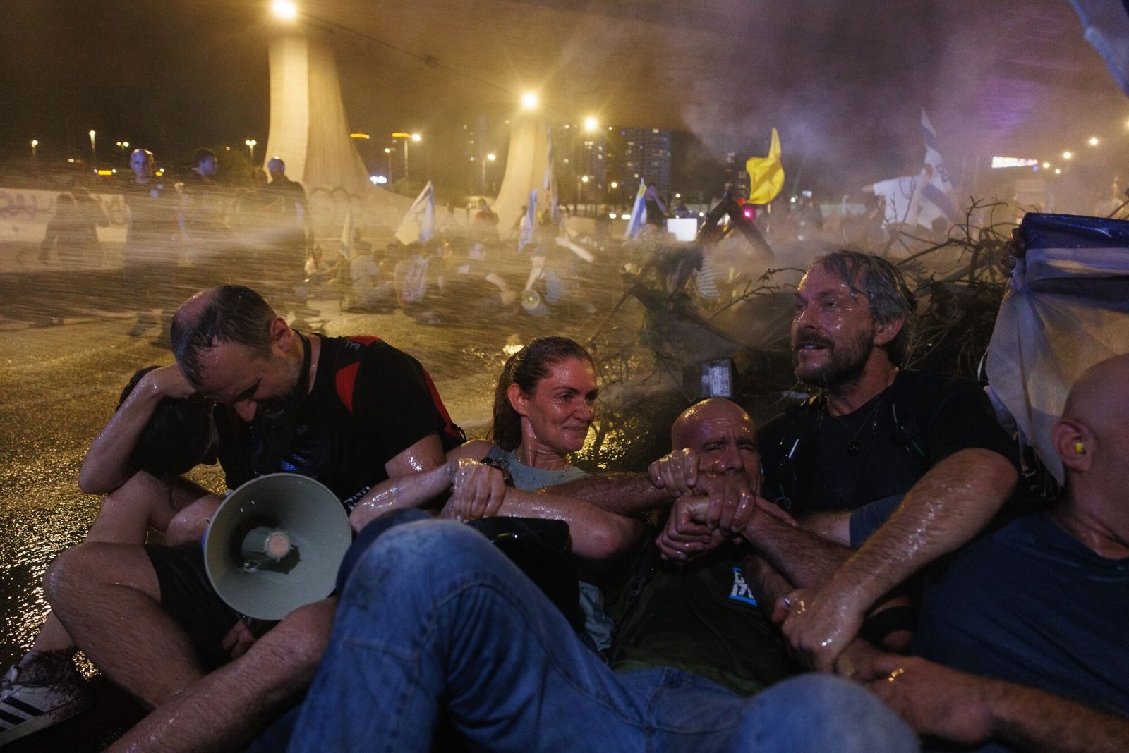 Israelis are sprayed by water as they block a highway while protesting for hostage release and against the government during a demonstration in Tel Aviv, Israel, on Sunday, Sept. 1, 2024. Hundreds of thousands of Israelis demonstrated in cities around the nation on Sunday � in what appeared to be the largest protests since the Oct. 7 attacks � after the bodies of six hostages were found in a tunnel in the Gaza Strip. Photographer: Kobi Wolf/Bloomberg