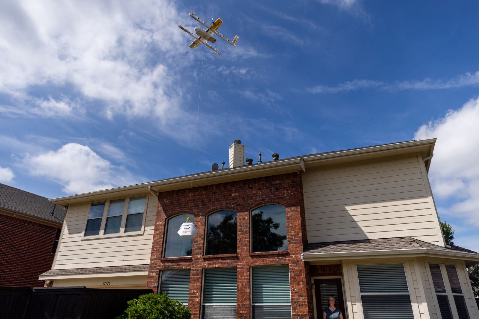 طائرة درون تحلق فوق أحد المنازل خلال توصيلها بعض الطلبات. - AFP