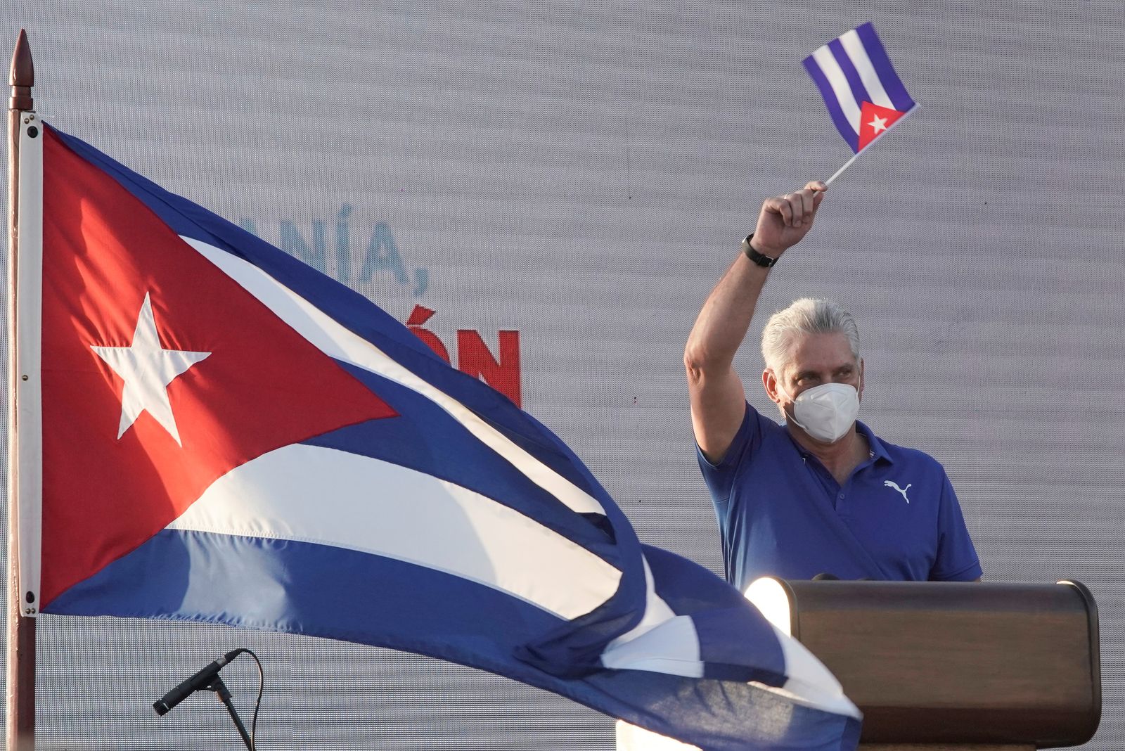 الرئيس الكوبي ميغيل دياز كانيل يلوّح بعلم بلاده خلال إلقائه خطاباً في هافانا - 17 يوليو 2021 - REUTERS
