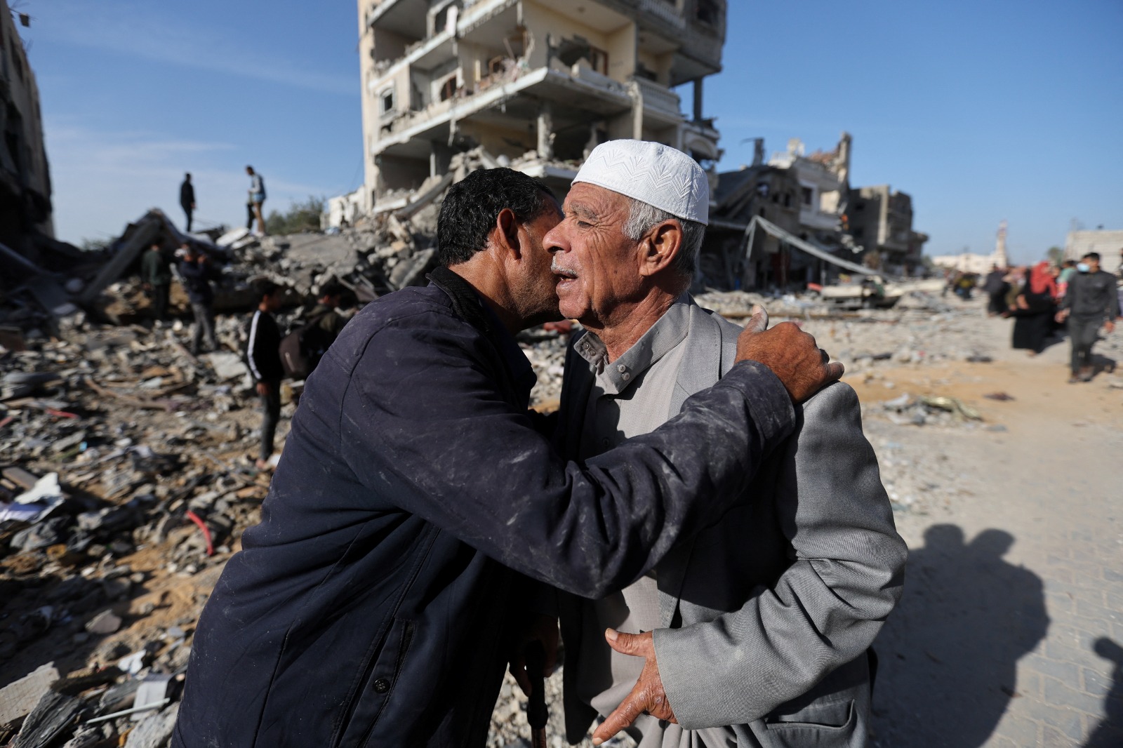 رجلان فلسطينيان بالقرب من منزل دمرته غارة إسرائيلية خلال الصراع وسط الهدنة المؤقتة بين حماس وإسرائيل، في خان يونس بجنوب قطاع غزة. 24 نوفمبر 2023