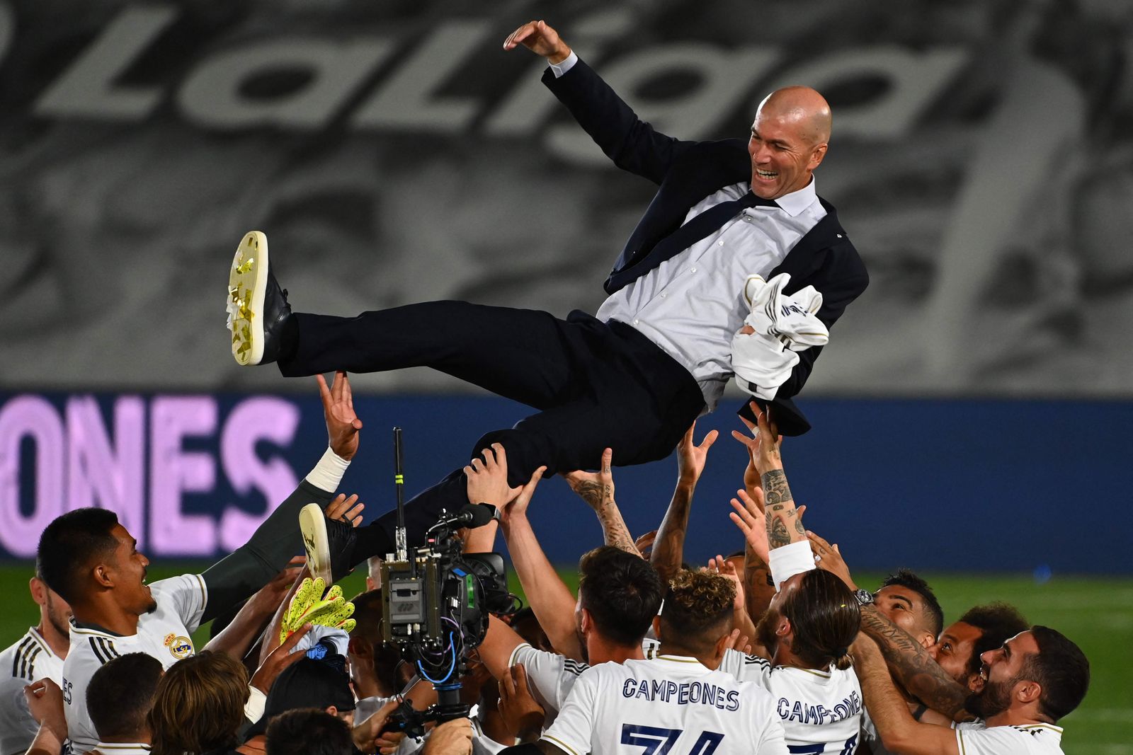 (FILES) In this file photo taken on July 16, 2020 Real Madrid's player toss Real Madrid's French coach Zinedine Zidane after winning the Liga title after the Spanish League football match between Real Madrid CF and Villarreal CF at the Alfredo di Stefano stadium in Valdebebas, on the outskirts of Madrid. - Zinedine Zidane resigned as Real Madrid manager because he felt the Spanish club no longer had any faith in him, he wrote in an open letter on May 31, 2021. (Photo by GABRIEL BOUYS / AFP) - AFP