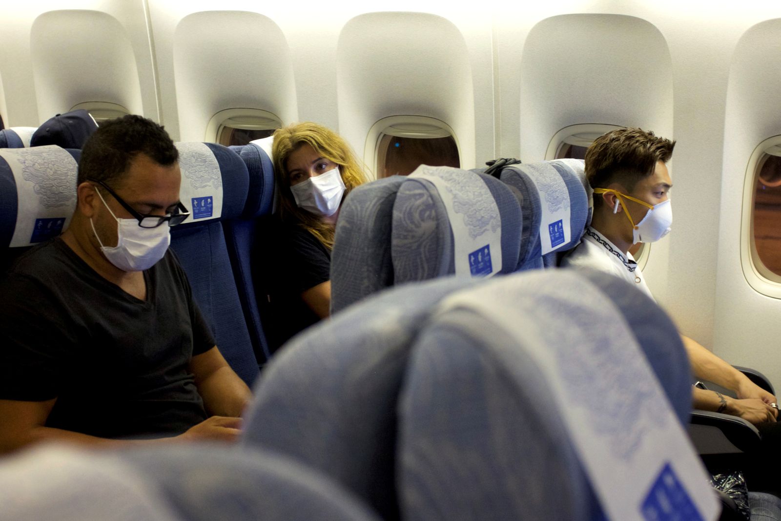 ركاب يرتدون أقنعة يجلسون على متن رحلة تابعة لشركة Air China متجهة من سيدني إلى بكين قبل الإقلاع في سيدني، أستراليا. 24 يناير 2020 - REUTERS