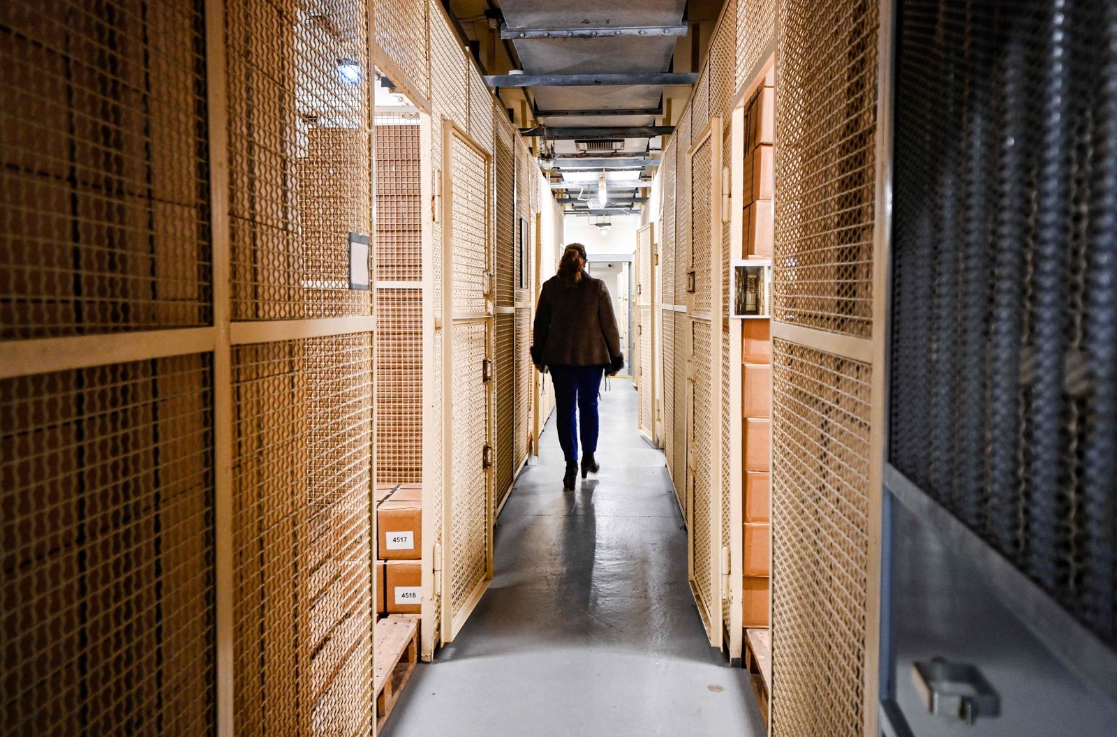 Petra Reuter, owner of the Bundesbank Bunker Museum, walks past storage rooms for the substitute currency in the former vault of the bunker museum in Cochem, western Germany on February 8, 2022. - The Bundesbank Bunker was a bunker of the German Federal Bank in Cochem for the storage of an emergency currency. From 1964 to 1988, up to 15 billion marks were stored in the top-secret facility to protect Germany from a national economic crisis in the event of hyperinflation caused by the Cold War. (Photo by Ina FASSBENDER / AFP) - AFP