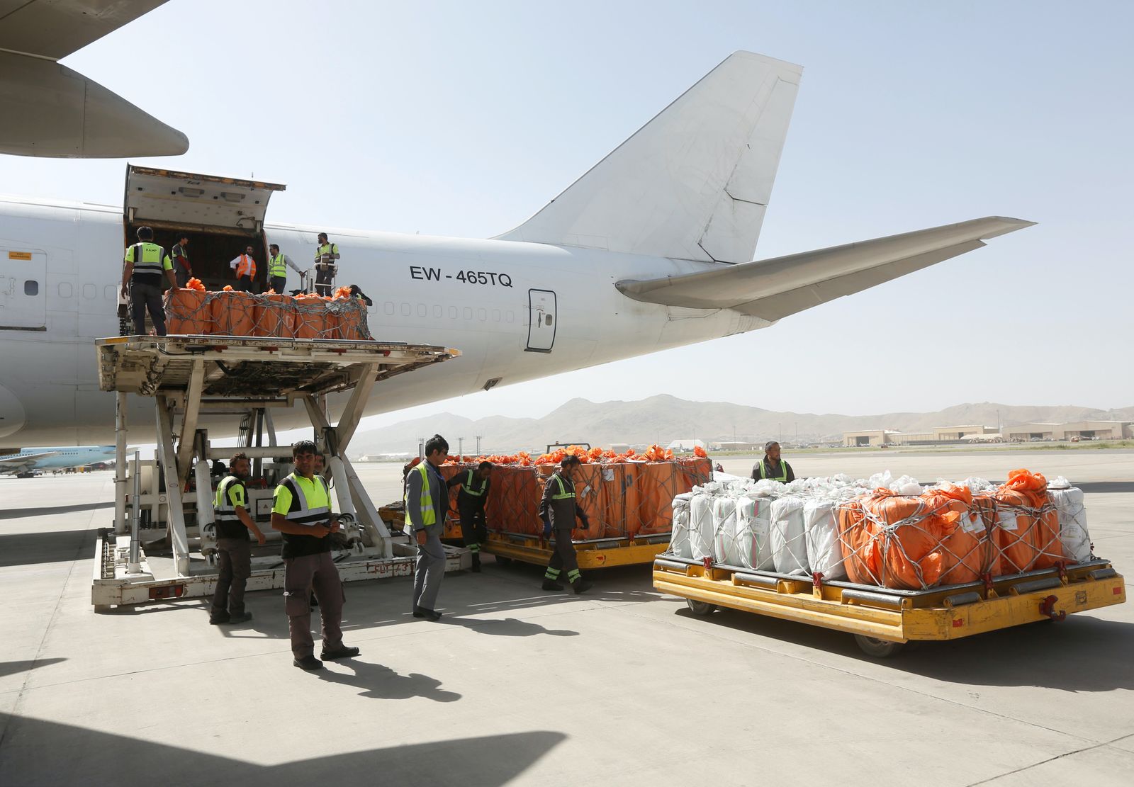 عمال يحمّلون بضائع على متن طائرة شحن في مطار كابول، قصد تصديرها. 19 يونيو 2017. - REUTERS