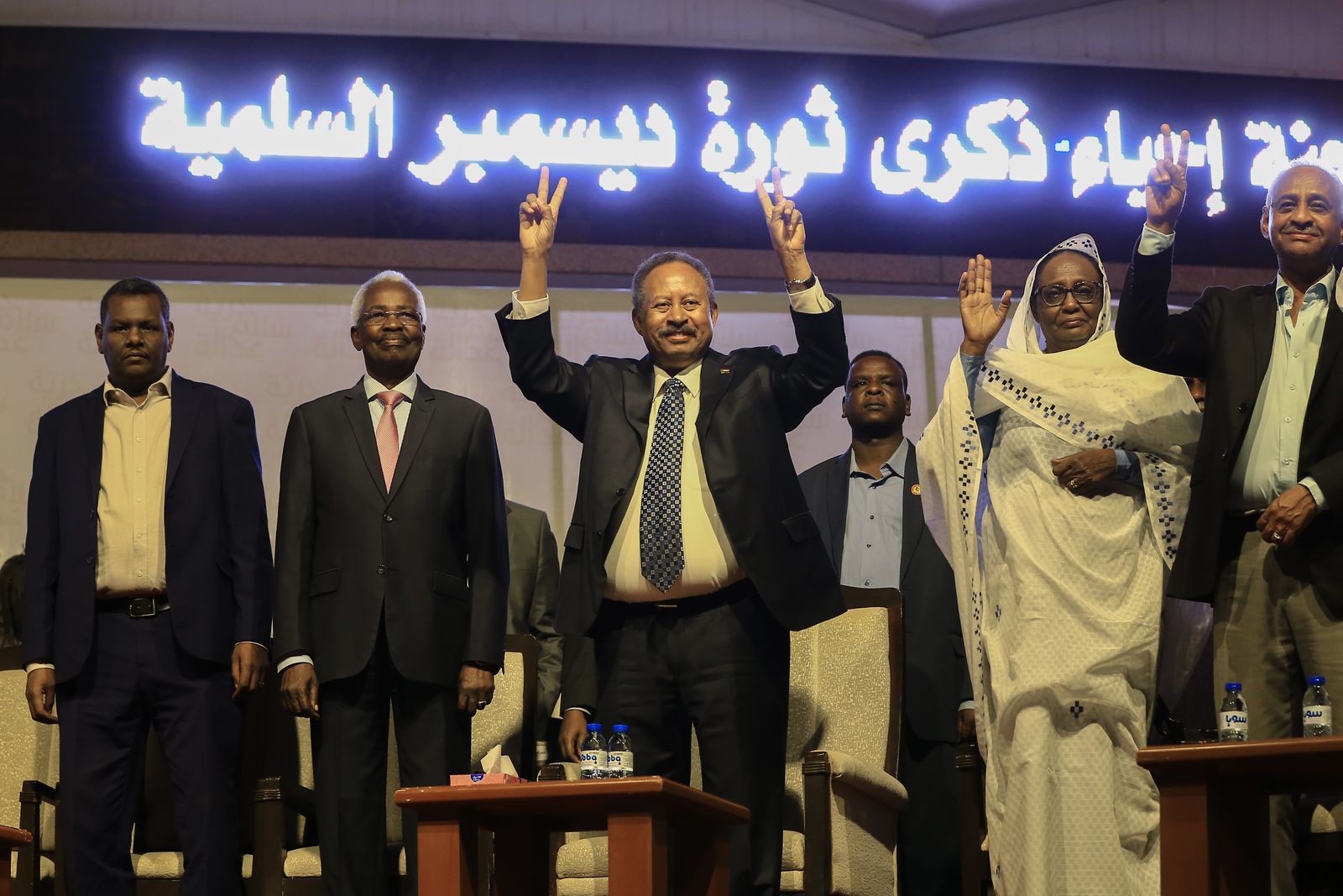 رئيس الوزراء السوداني عبد الله حمدوك (وسط) يضيء علامة النصر خلال احتفال بمناسبة الذكرى الأولى للانتفاضة التي أطاحت عمر البشير ، في الخرطوم ، 25 ديسمبر ، 2019. (تصوير أشرف شاذلي / وكالة الصحافة الفرنسية), AFP