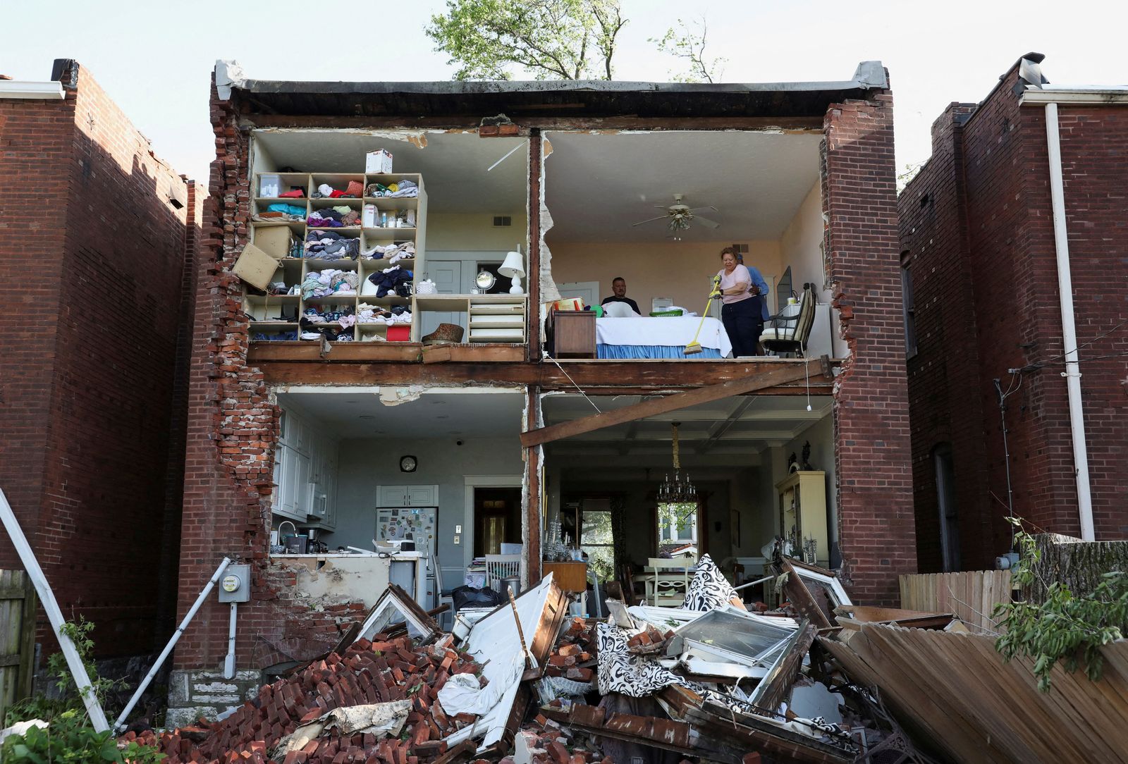 Residents inspect their home after a tornado completely tore off the back wall of a two-story house in St. Louis, Missouri,U.S. May 16, 2025. REUTERS/Lawrence Bryant     TPX IMAGES OF THE DAY
