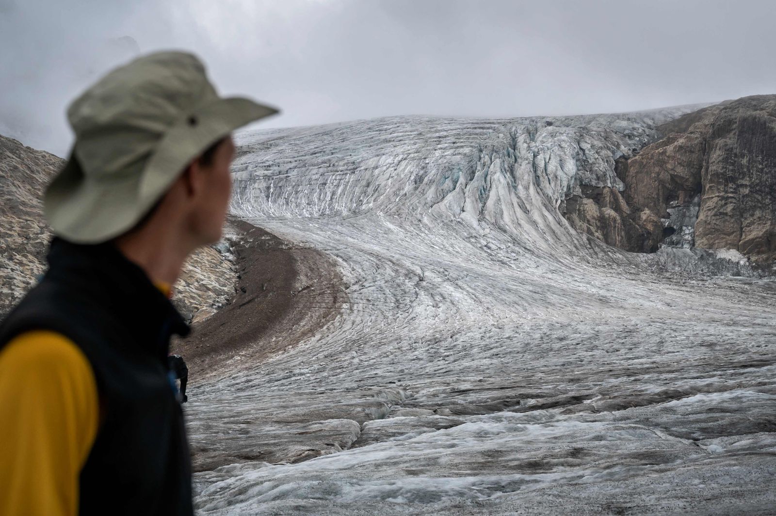 This picture taken on September 2, 2022 above Ulrichen shows glaciologist and head of 'Glacier Monitoring in Switzerland' (GLAMOS) network Matthias Huss reacting during a visit with his team on the Gries glacier to takes readings of measuring equipments. - Swiss glaciers smashed all records for melting in 2022, under the dual effect of a dry winter and a long wave of intense summer heat. Three cubic kilometres of ice - three thousand billion litres of water - literally evaporated, or 6% of the total volume of Swiss glaciers, according to a report by the (GLAMOS) network published on September 28, 2022. (Photo by Fabrice COFFRINI / AFP) - AFP