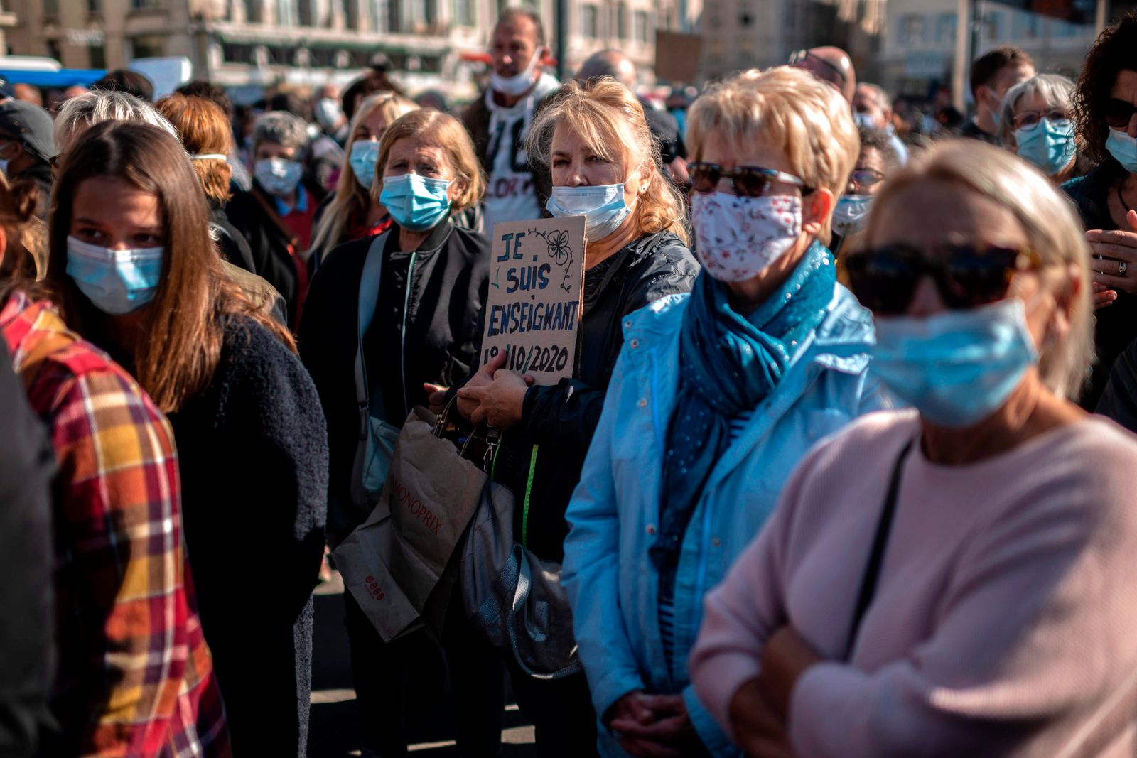 A woman holds a placard reading 