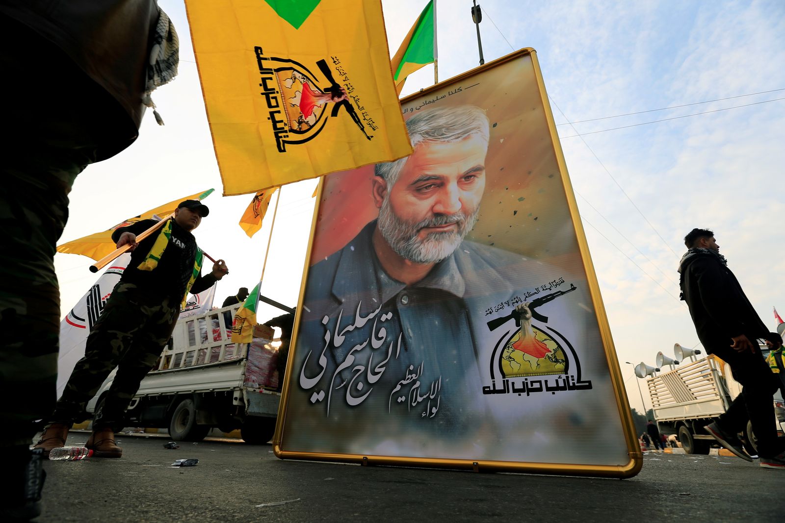 عناصر من حزب الله العراقي يحملون صورة قاسم سليماني خلال تشييع نائب قائد الحشد الشعبي أبو مهدي المهندس في بغداد- 4 يناير 2020 - REUTERS
