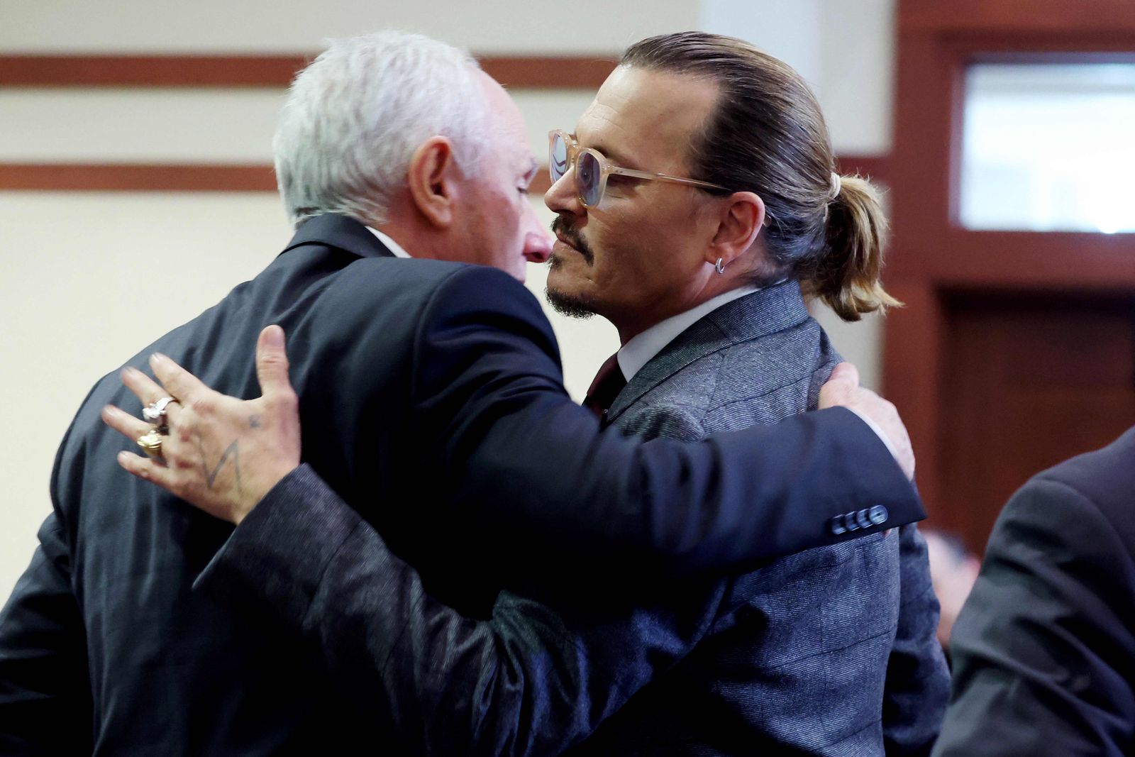US actor Johnny Depp (R) embraces his business manager Edward White (L) as court finishes for the day during the 50 million US dollar Depp vs Heard defamation trial at the Fairfax County Circuit Court in Fairfax, Virginia, April 28, 2022. - US actor Johnny Depp sued his ex-wife Amber Heard for libel in Fairfax County Circuit Court after she wrote an op-ed piece in The Washington Post in 2018 referring to herself as a 