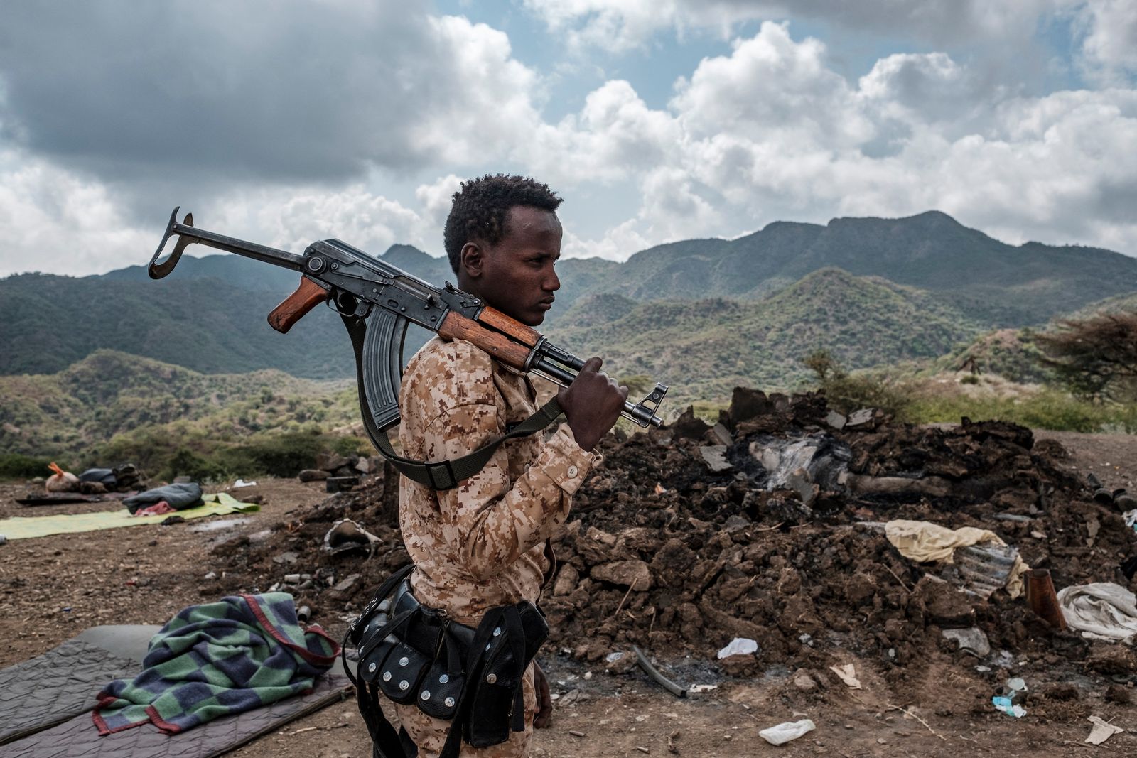 أحد أفراد القوات الإريترية يقف أمام حطام منزل في ضواحي قرية بيسوبر بإقليم تيغراي، إثيوبيا  - AFP