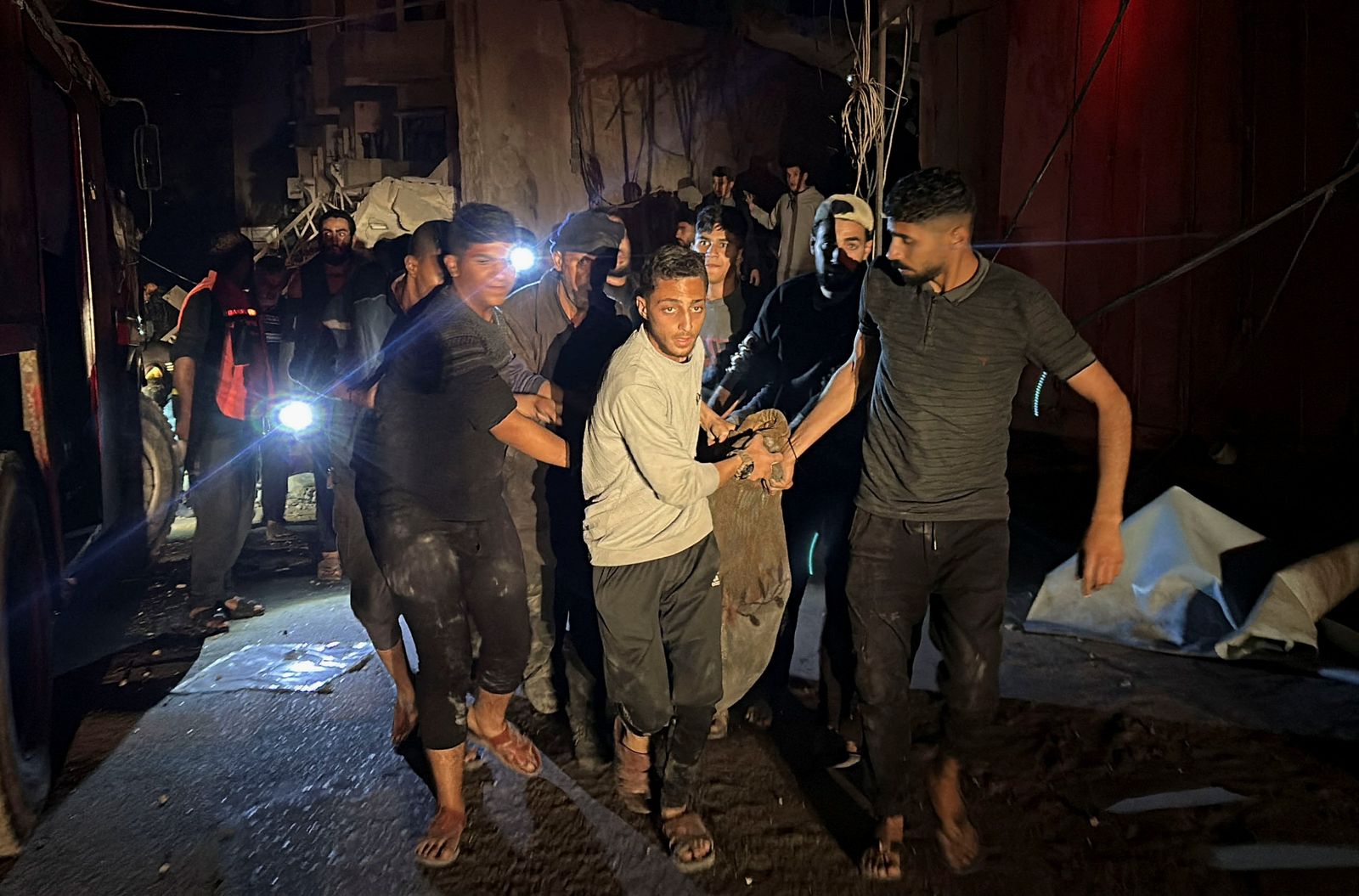 People carry a casualty following an Israeli strike at a post office where people were sheltering in Nuseirat in central Gaza Strip December 12, 2024. REUTERS/Khamis Said