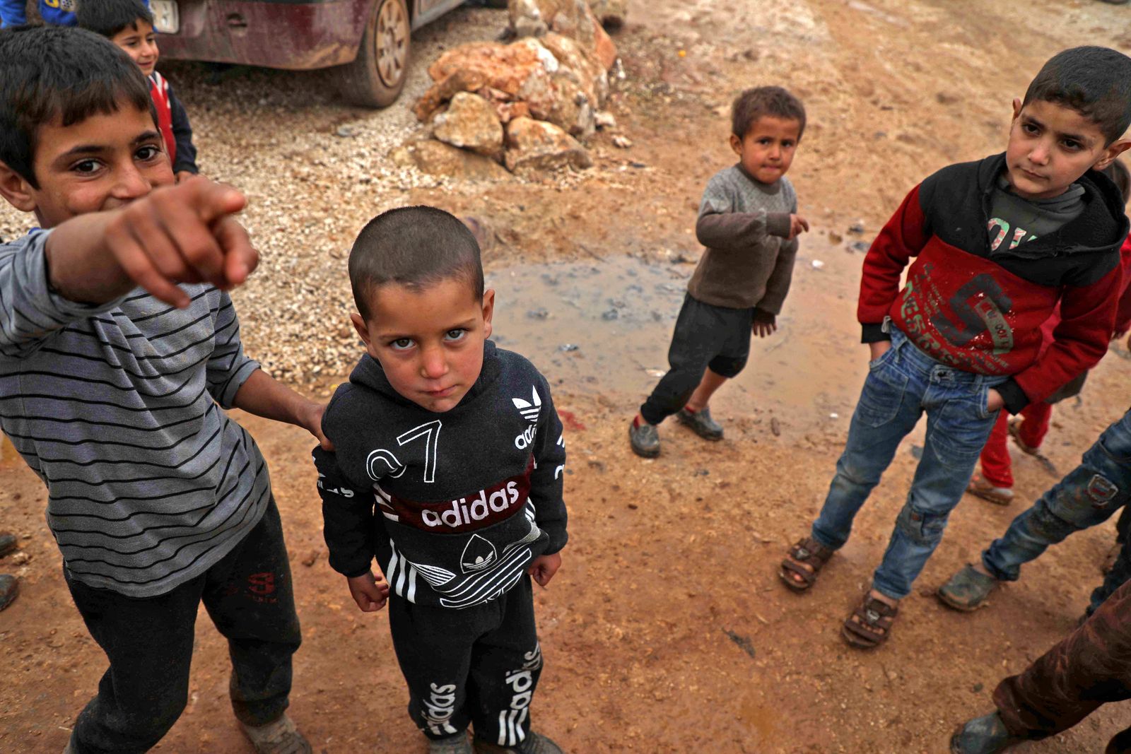 Syrian children pose for a picture at a camp for displaced Syrians near the town of Kafr Lusin by the border with Turkey, in Syria's rebel-held northwestern province of Idlib on December 15, 2020. (Photo by Aaref WATAD / AFP) - AFP