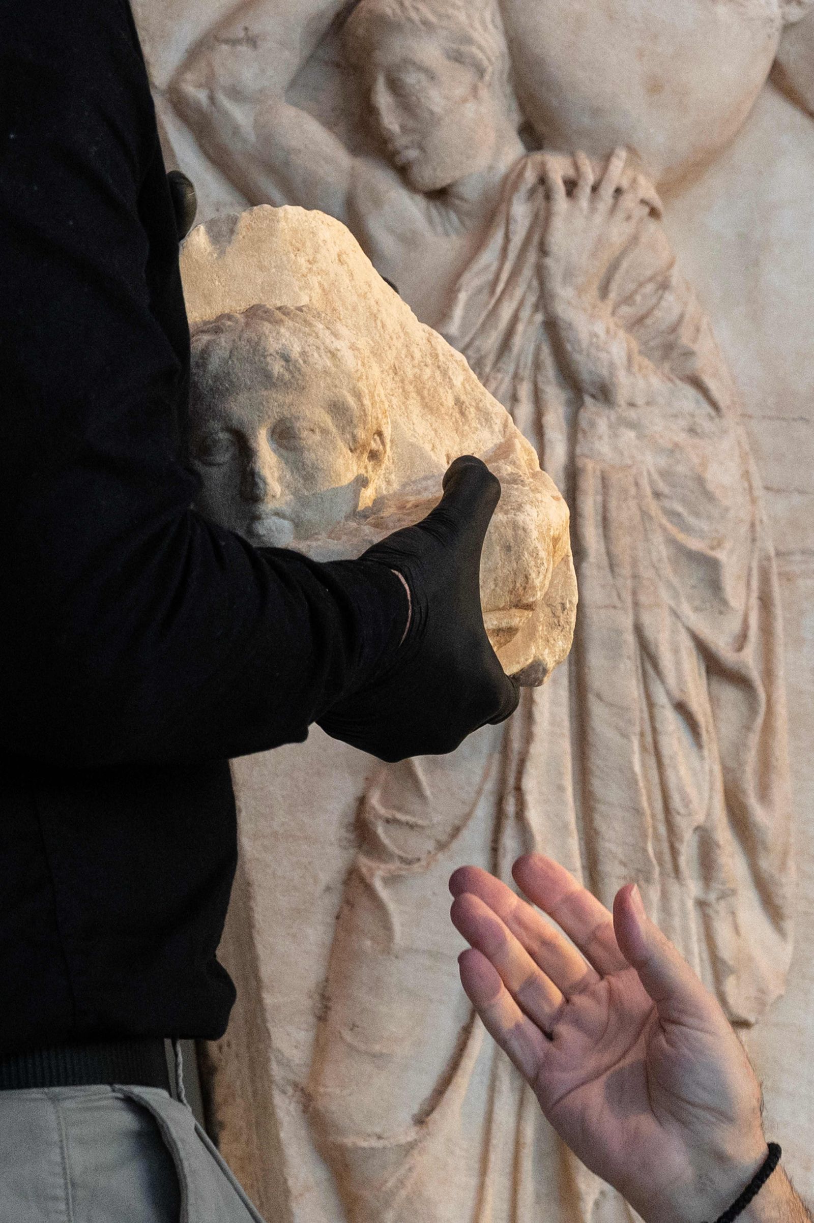 Acropolis Museum Director Nikolaos Stampolidis (R) and a curator hold one of the three fragments of the Parthenon, during a ceremony at the Acropolis Museum in Athens on March 24, 2023. - Pope Francis returned to Greece three fragments of Athens' Parthenon temple, in what the Vatican called a gesture of friendship. (Photo by Angelos Tzortzinis / AFP) - AFP