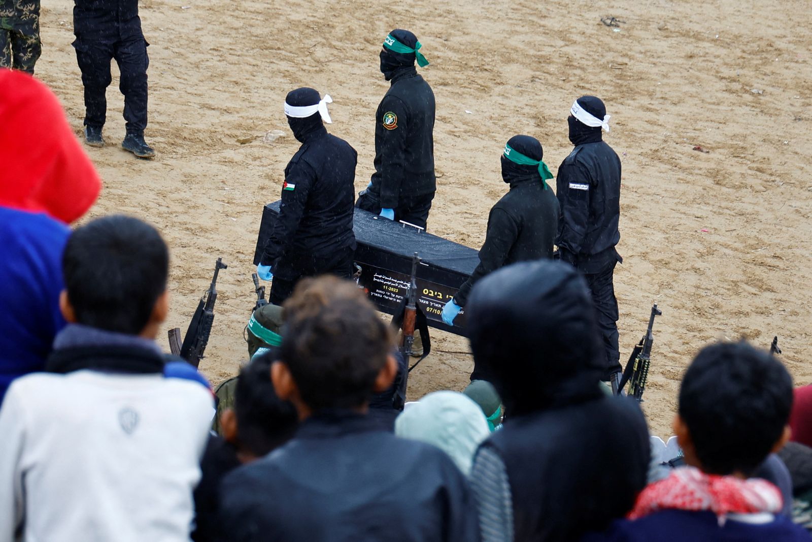 Palestinian militants carry a coffin on the day Hamas hands over deceased hostages Oded Lifschitz, Shiri Bibas and her two children Kfir and Ariel Bibas, seized during the deadly October 7, 2023 attack, to the Red Cross, as part of a ceasefire and hostages-prisoners swap deal between Hamas and Israel, in Khan Younis in the southern Gaza Strip February 20, 2025. REUTERS/Hatem Khaled