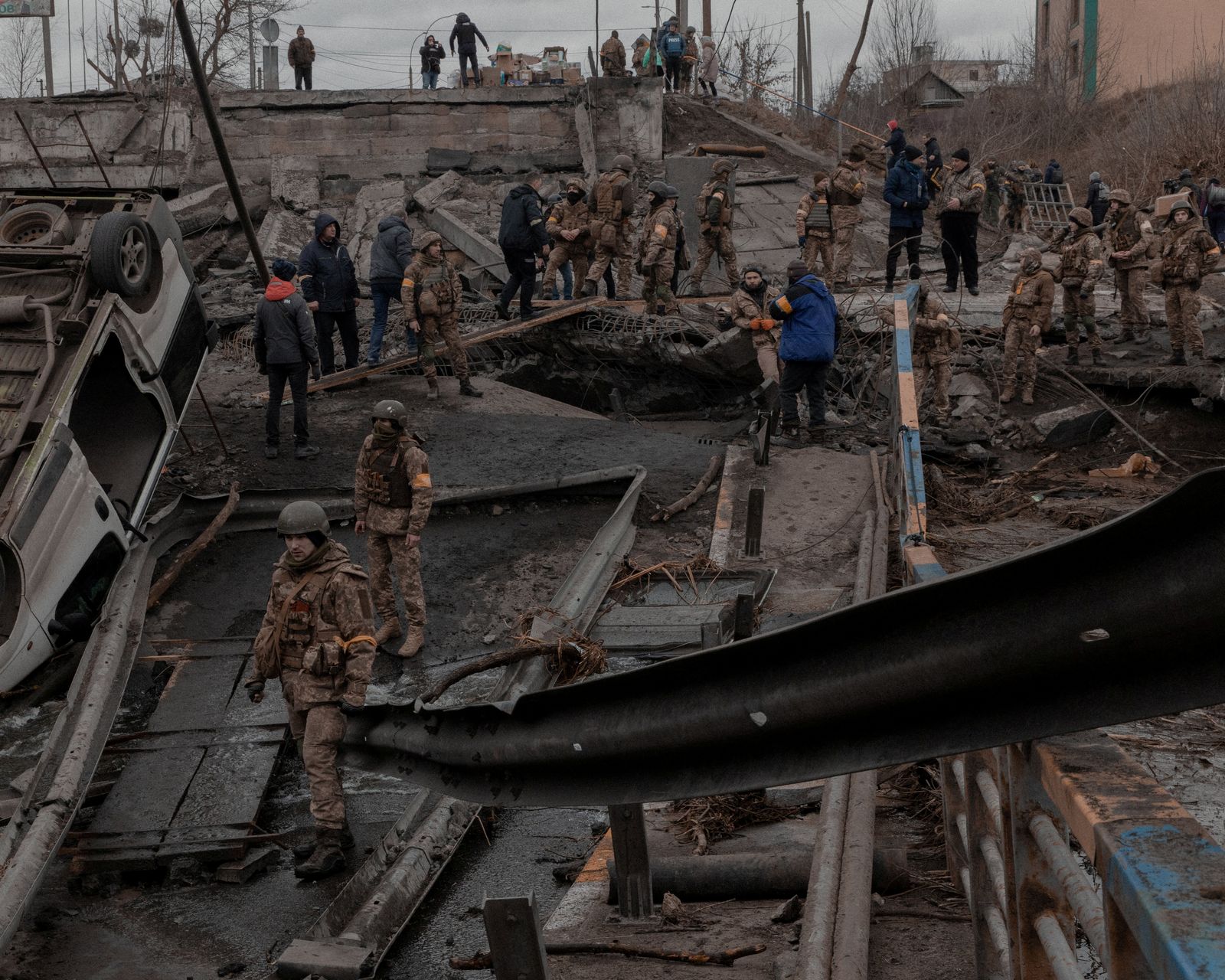 جنود أوكرانيون يقفون بجوار جسر مدمر في مدينة إيربين في منطقة كييف ، أوكرانيا - 5 مارس 2022 - REUTERS