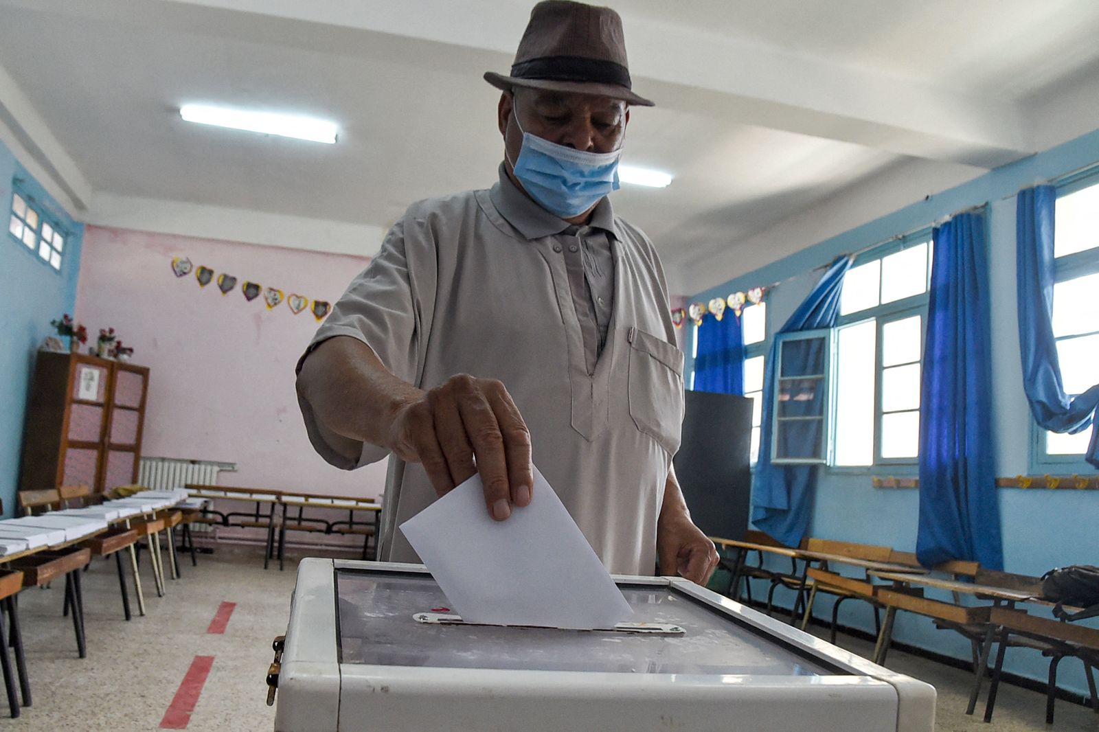 مواطن جزائري يدلي بصوته خلال الانتخابات التشريعية الجزائرية في مركز اقتراع على أطراف العاصمة الجزائر 12 يونيو 2021 - AFP