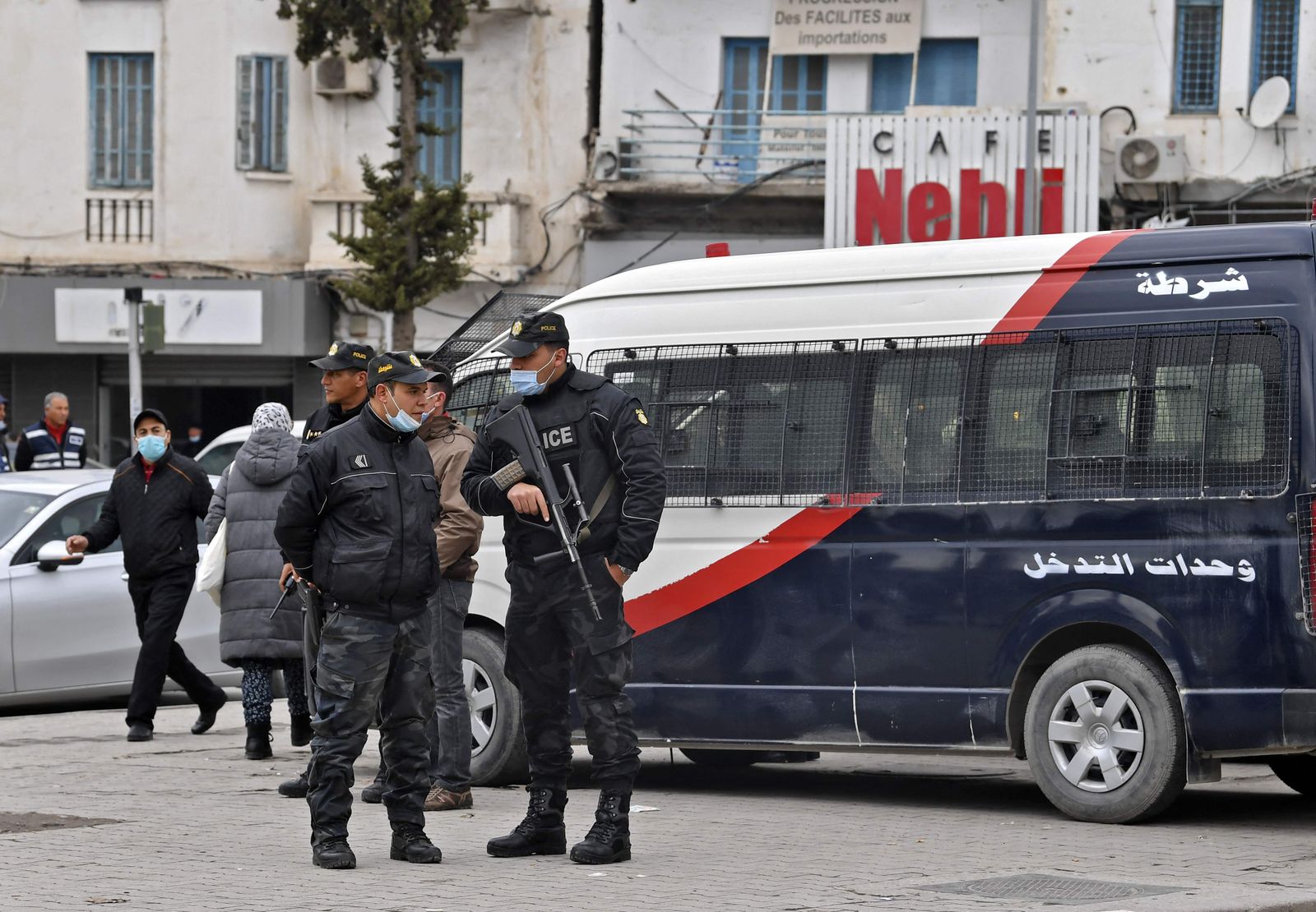 Tunisian security forces stand guard in the capital Tunis, on January 14, 2022. - Tunisia's Islamist-inspired Ennahdha party reiterated calls for demonstrations on January 14,  marking the anniversary of the country's revolution and defying tightened coronavirus restrictions. But on January 12, the President's office announced new measures against mounting coronavirus cases, including a nighttime curfew and a ban on public gatherings. (Photo by FETHI BELAID / AFP) - AFP