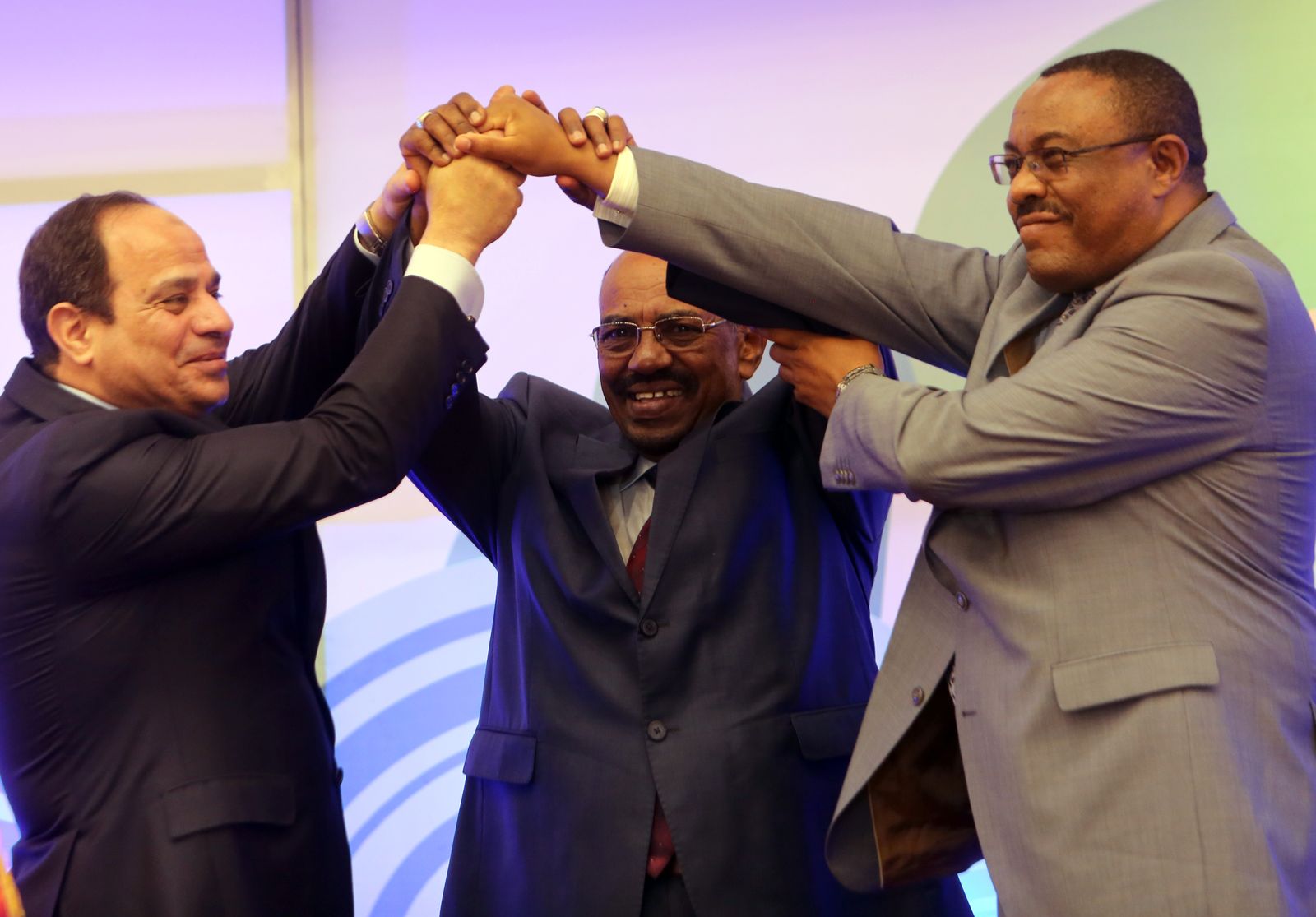 الرئيس المصري عبد الفتاح السيسي، والرئيس السوداني السابق عمر البشير ورئيس الوزراء الإثيوبي السابق هايلي مريام ديسالين يحتفلون بتوقيع اتفاق المبادئ بشأن سد النهضة في الخرطوم. 23 مارس 2015 - AFP