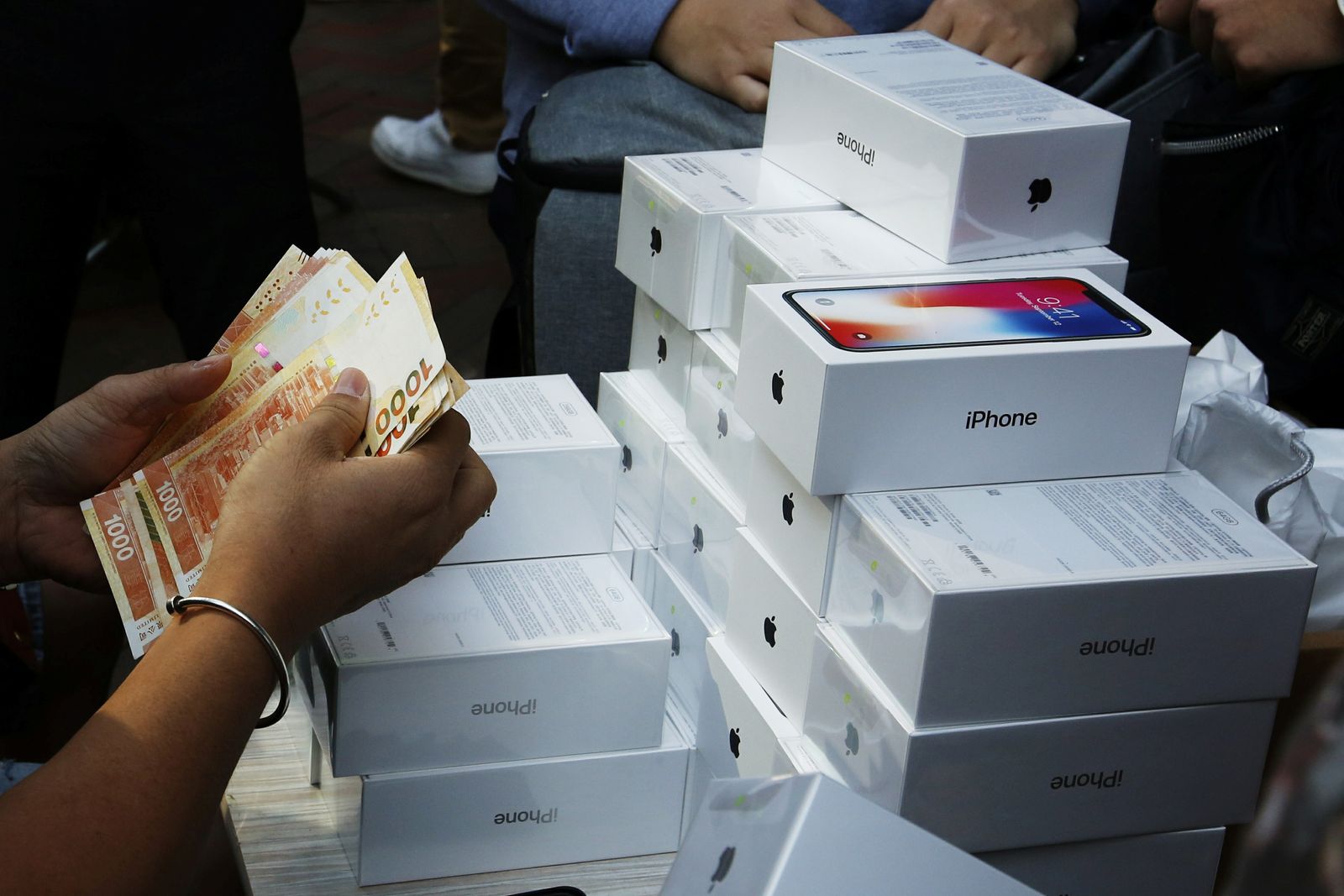 رجل يدفع لشراء iPhone Xs في متاجر Apple في أحد شوارع هونج كونج-3 نوفمبر  2017. - REUTERS