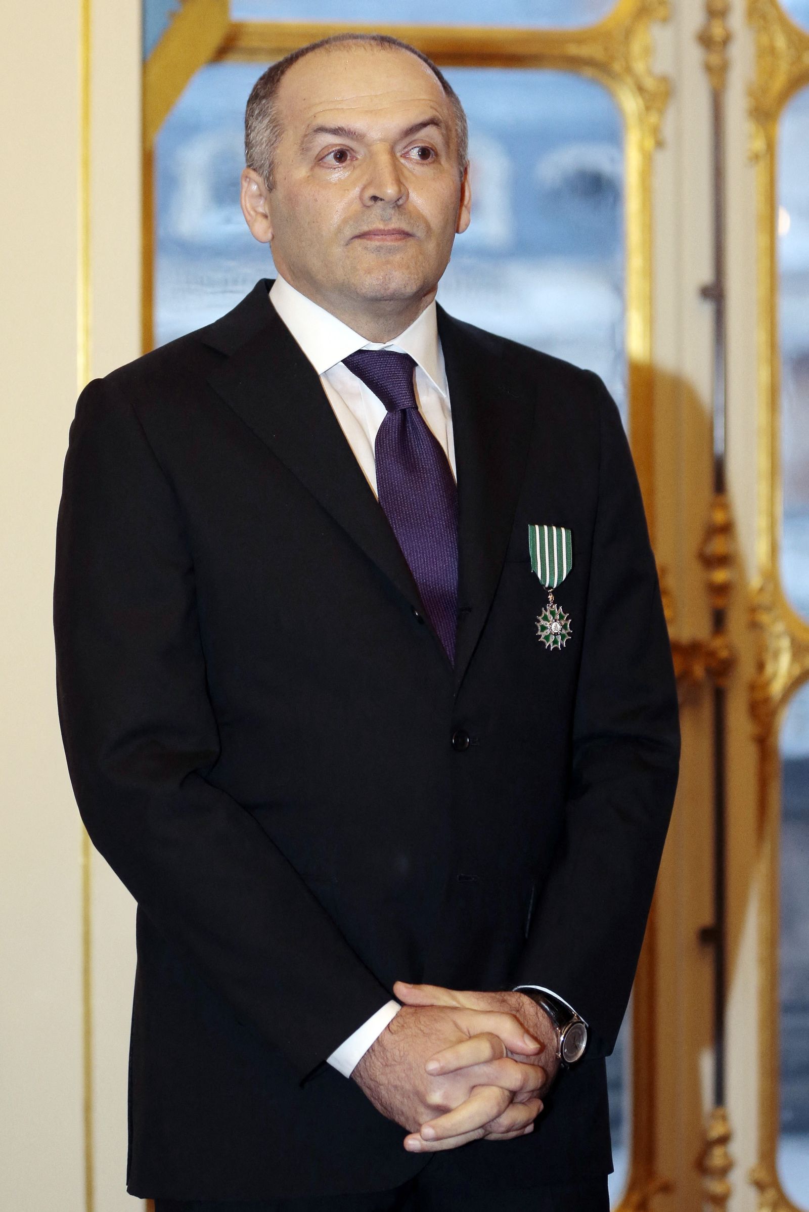 رجل الأعمال الأوكراني فيكتور بينشوك يقف بعد حصوله على وسام شوفالييه للفنون والآداب من وزير الثقافة الفرنسي- 27 مارس 2013 - AFP