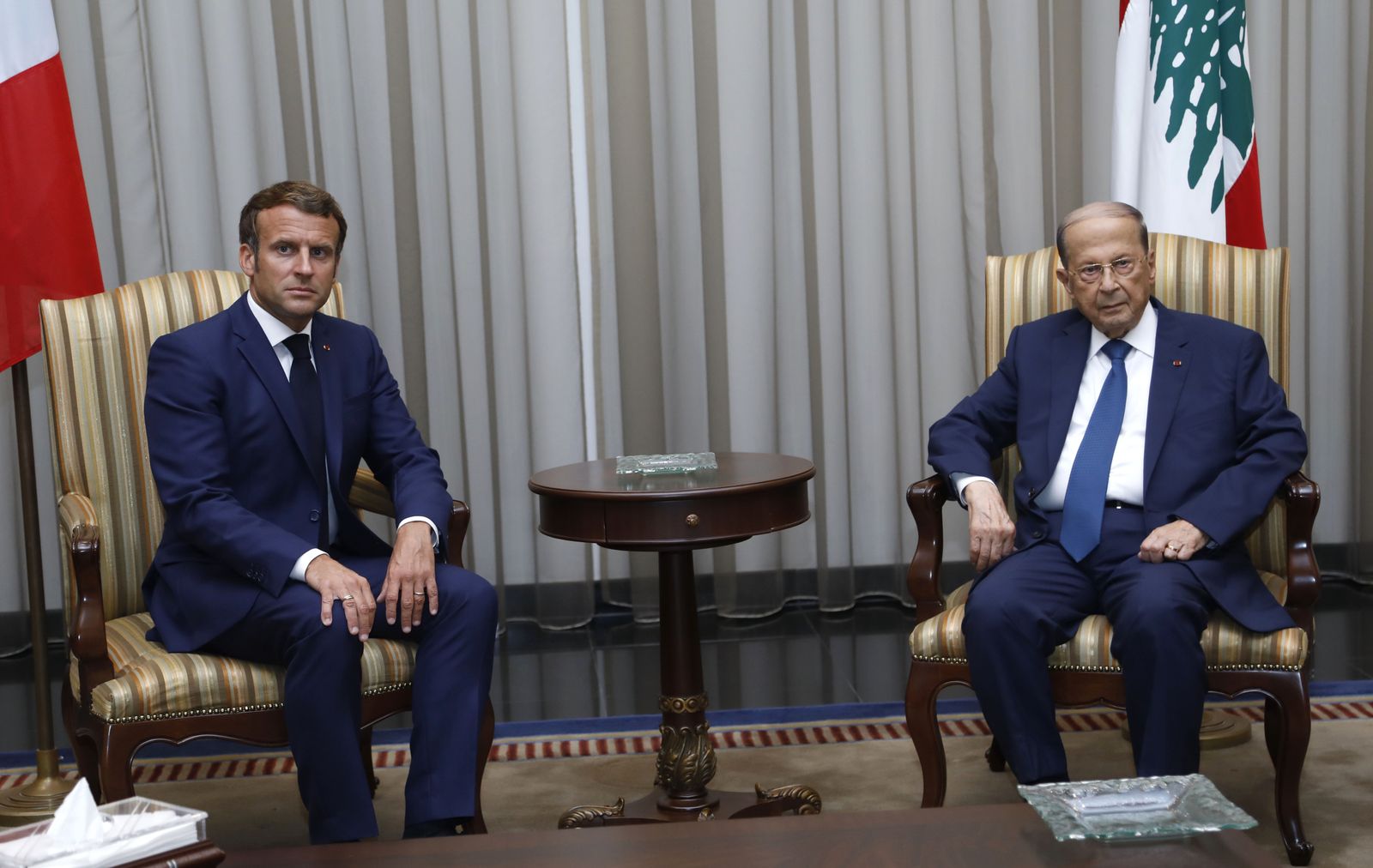 عون يستقبل ماكرون في مطار بيروت في 6 أغسطس 2020 بعد يومين من انفجار المرفأ - AFP