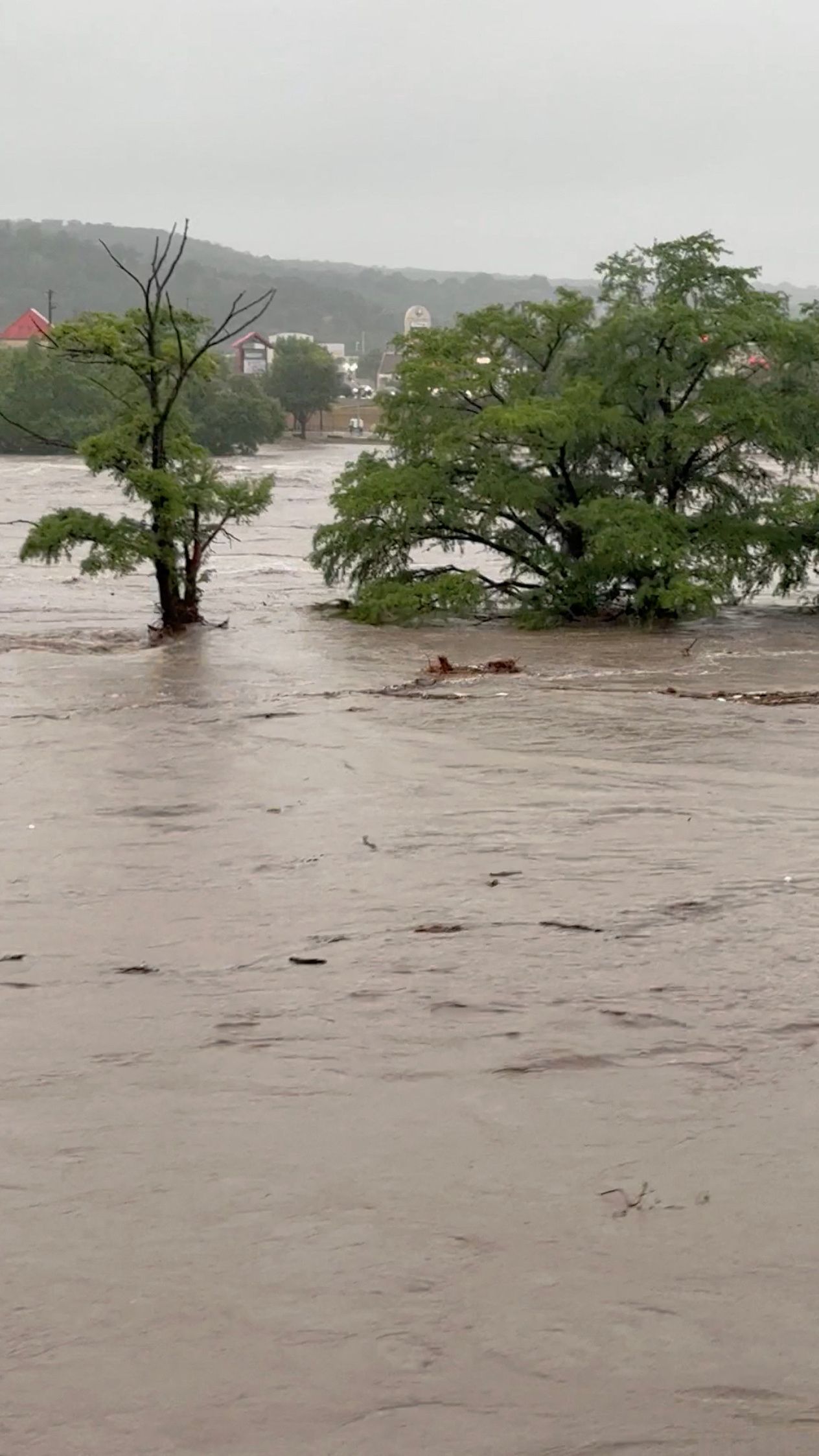 Trees stand partially submerged after storms caused massive flooding from the swollen Guadalupe River in Kerrville, Texas, U.S., July 4, 2025 in this still image from video obtained from social media. Michael Moad/via REUTERS  THIS IMAGE HAS BEEN SUPPLIED BY A THIRD PARTY. MANDATORY CREDIT. NO RESALES. NO ARCHIVES.