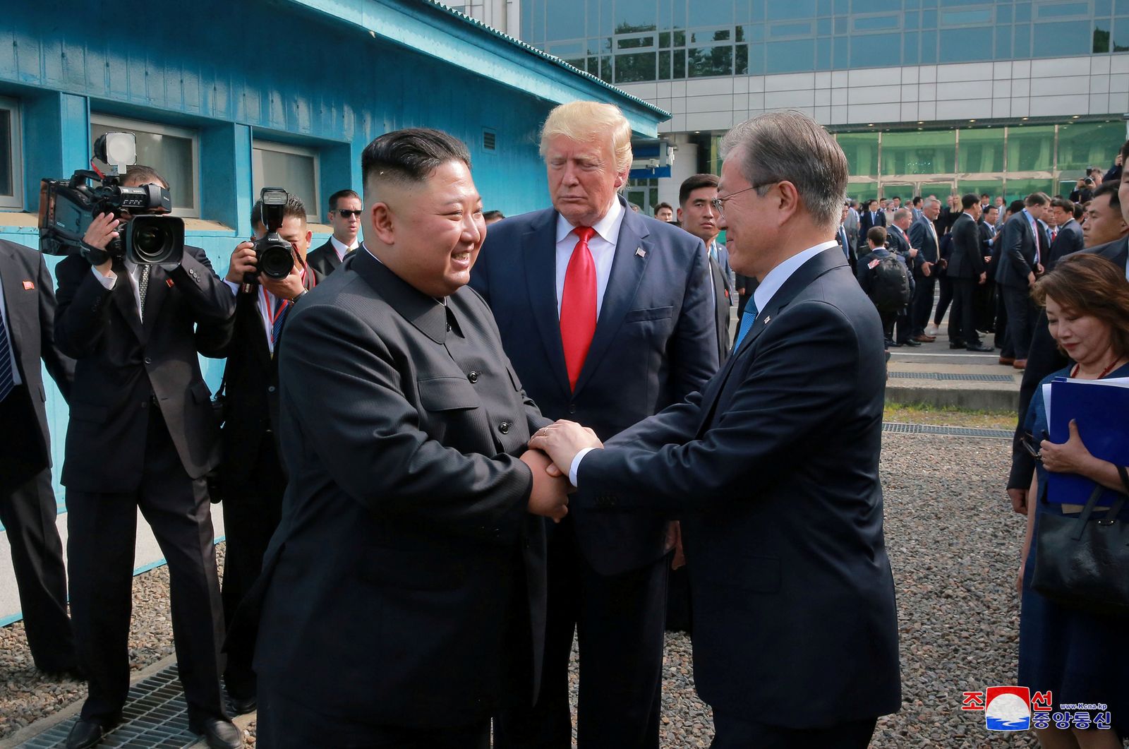 الرئيس الأميركي السابق دونالد ترمب متوسّطاً الرئيس الكوري الجنوبي مون جاي إن (يمين) والزعيم الكوري الشمالي كيم جونغ أون، في المنطقة المنزوعة السلاح بين الكوريتين - يونيو 2019 - REUTERS