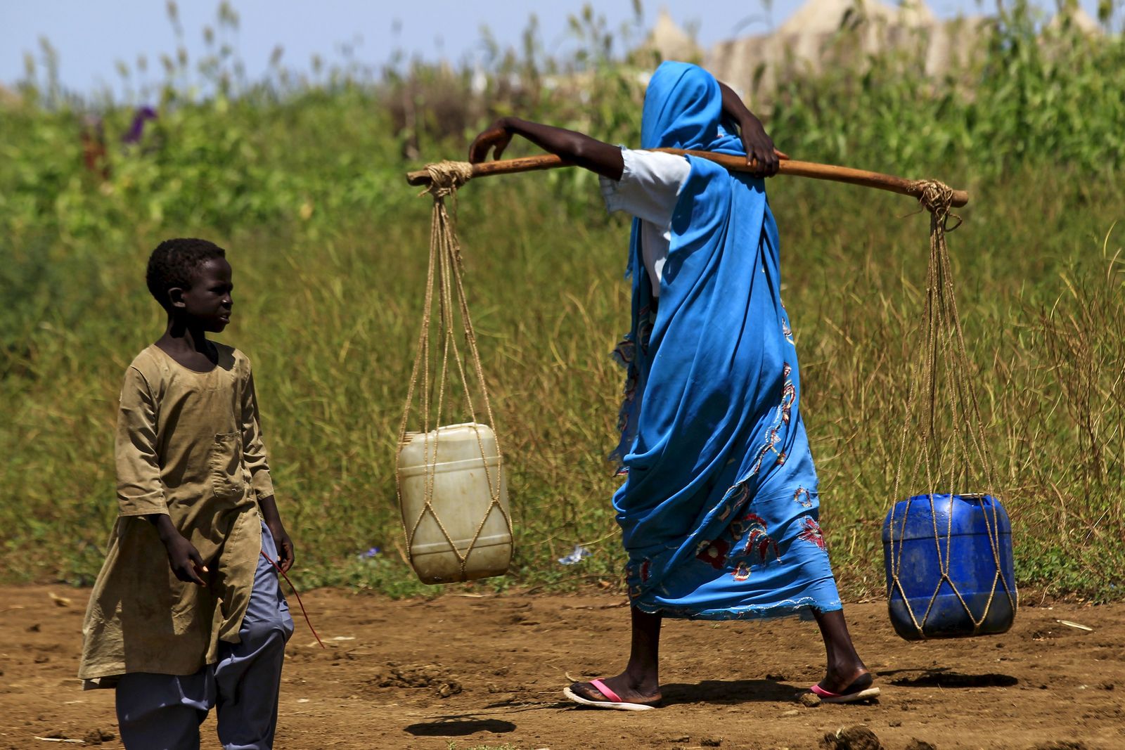 امرأة تحمل الماء في شرق الدمازين عاصمة ولاية النيل الأزرق بالسودان - REUTERS