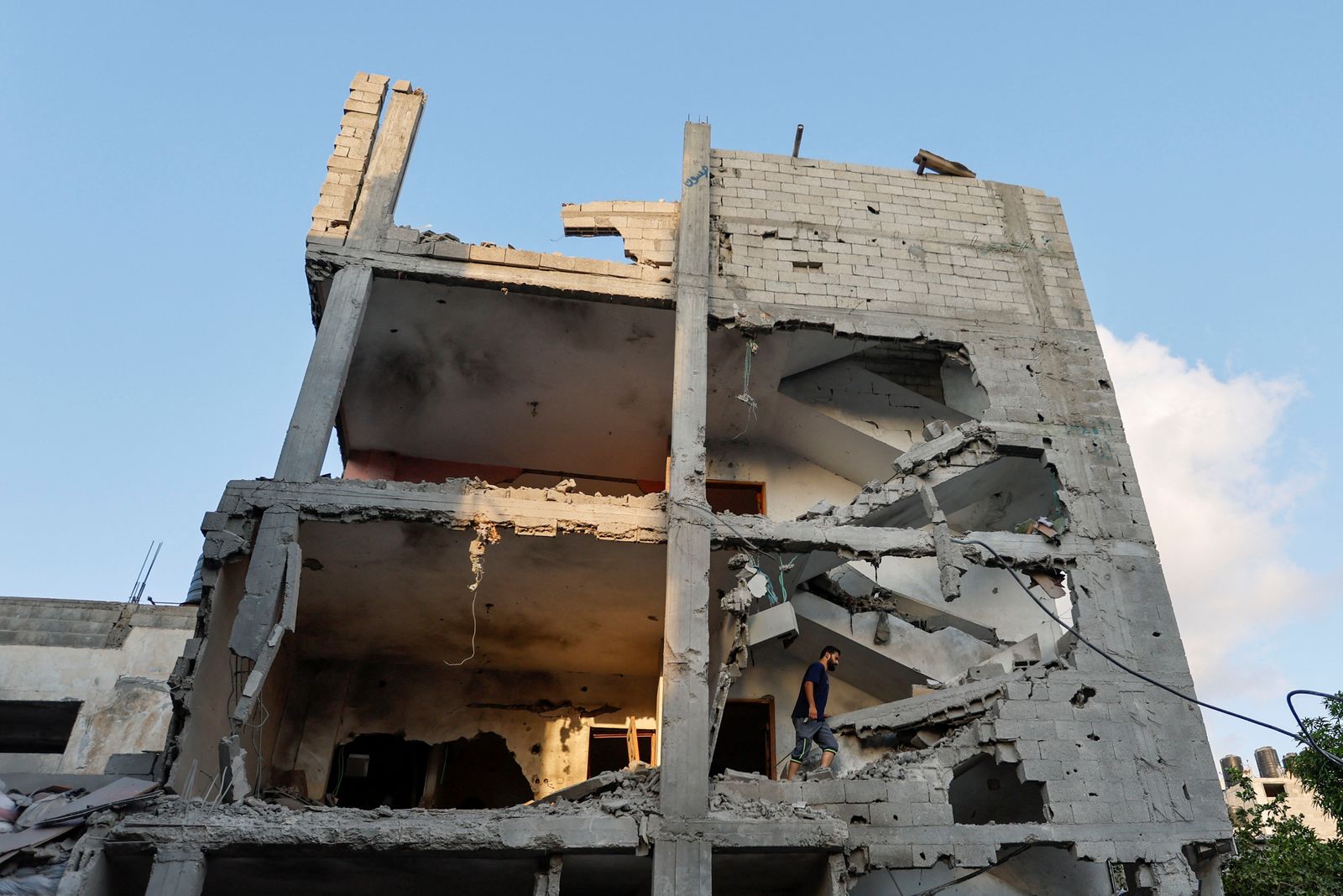 فلسطيني يتفقد أنقاض منزل دمرته غارات إسرائيلية في رفح جنوب قطاع غزة- 7 أغسطس 2022 - REUTERS