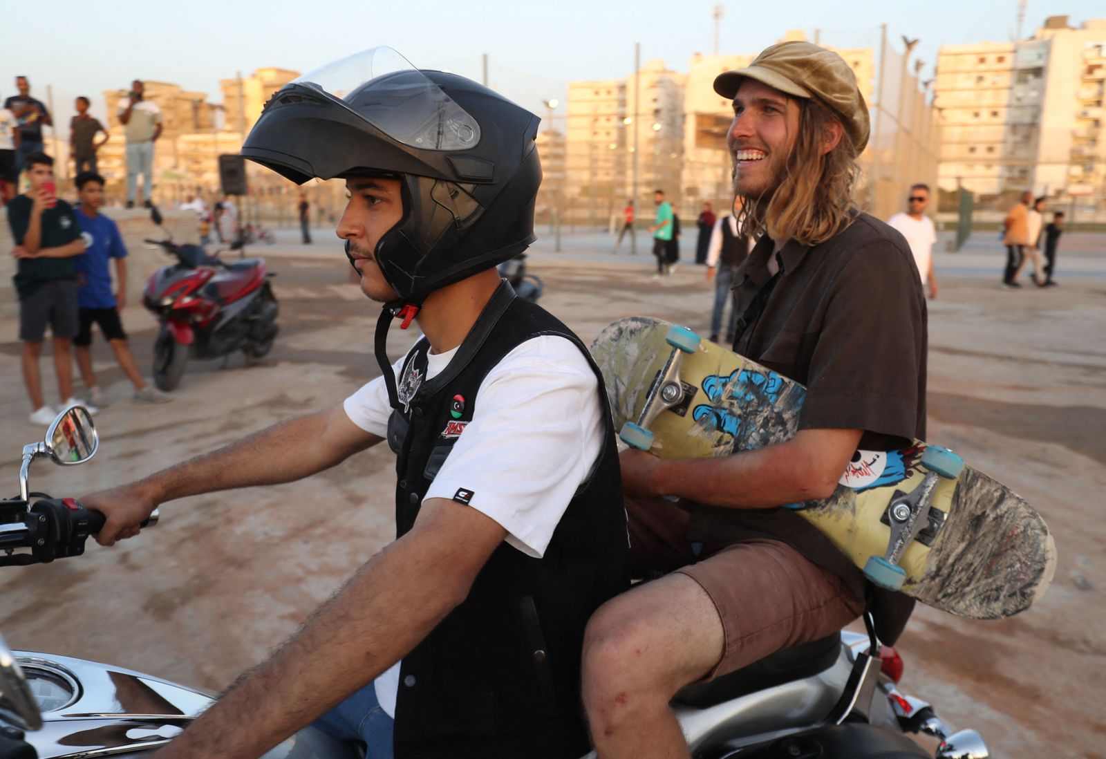 A skateboarder arrives to show off his skills during the inauguration of a skatepark, a first in Libya, in the capital Tripoli, on May 29, 2022. - In the new playground, financed by the US embassy in Tripoli and built by the Make Life Skate Life NGO with the contribution of volunteers from all over the world, apprentice skaters rush at full speed on the ramps to perform jumps and tricks, others chat happily or compete for selfies. (Photo by Mahmud Turkia / AFP) - AFP