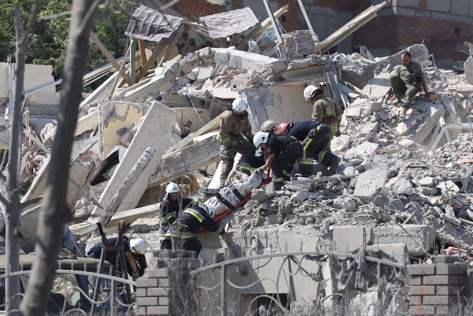 Rescuers evacuate the body of a person from a destroyed building after being hit by a missile strike in the Ukrainian town of Serhiivka, near Odessa, killing at least 18 people and injuring 30, on July 1, 2022. - During the night from June 30 to July 1, 2022, two missiles were fired by a 