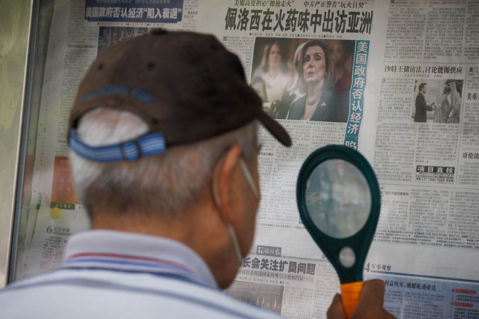 A man reads a newspaper that features an article about U.S. House of Representatives Speaker Nancy Pelosi's Asia tour, in Beijing - REUTERS
