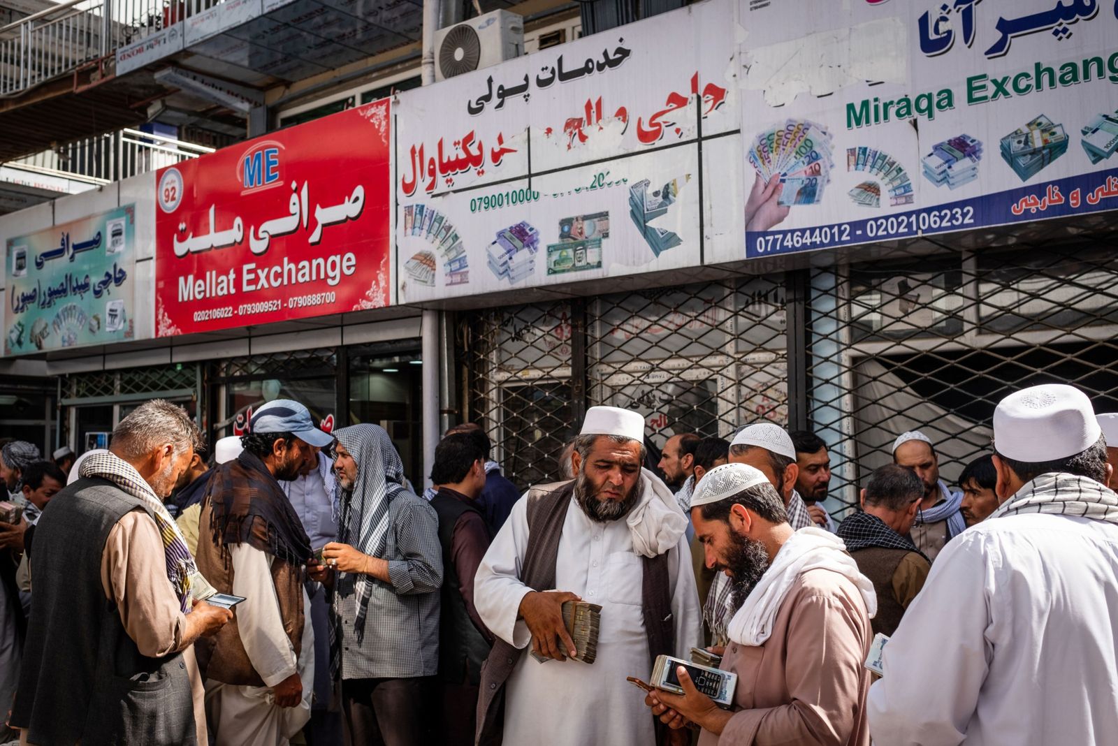 يحملون نقوداً أمام محال صيرفة في كابول - 12 يوليو 2018 - Bloomberg