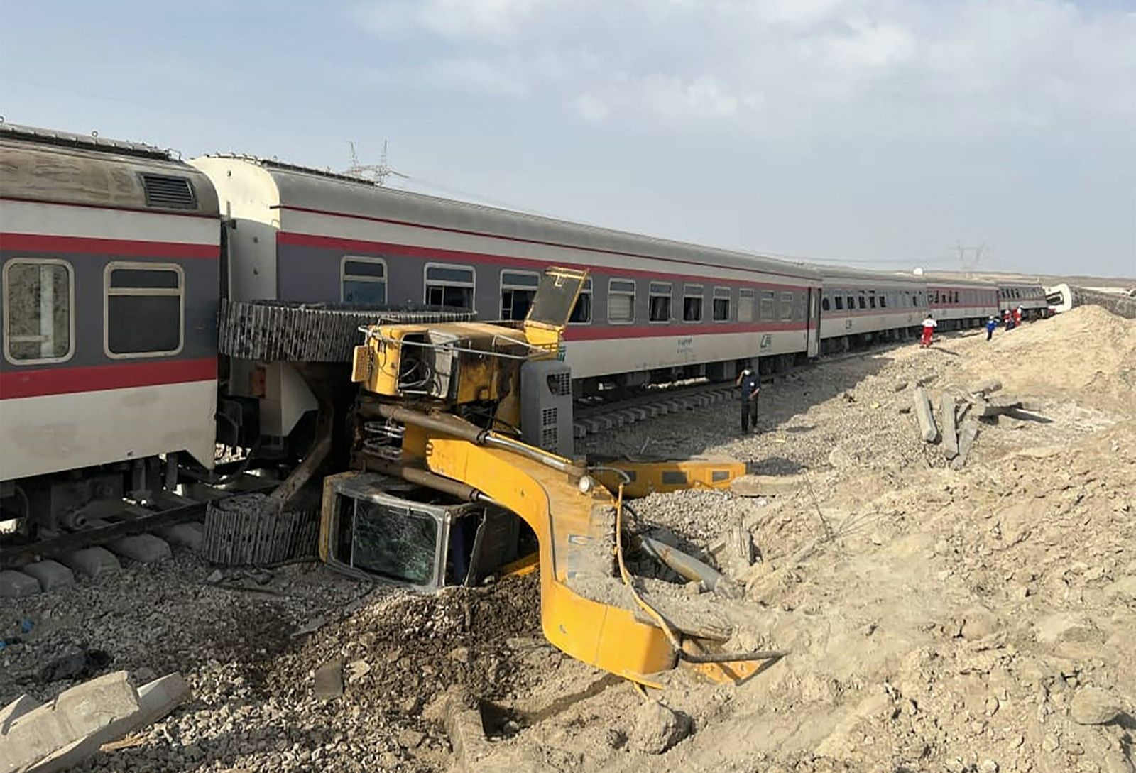 A handout picture made available by the Iranian Red Crescent on June 8, 2022 shows a train derailed after hitting an excavator near the central Iranian city of Tabas, on the line between the cities of Mashhad and Yazd. - More than a dozen people were killed and injured when a train derailed near Tabas after hitting an excavator, state media reported. (Photo by Iranian Red Crescent / AFP) / === RESTRICTED TO EDITORIAL USE - MANDATORY CREDIT 