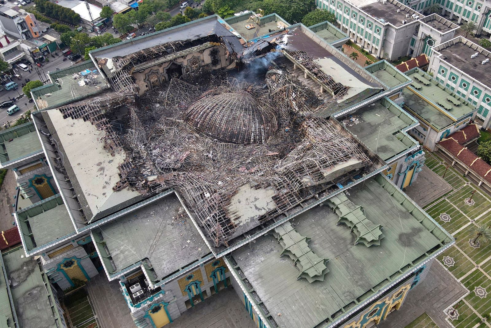 This aerial picture taken on October 20, 2022 shows the smouldering remains of the collapsed dome of the Islamic Centre mosque in Jakarta, which caught fire during ongoing renovation work. (Photo by BAGUS SARAGIH / AFP) - AFP