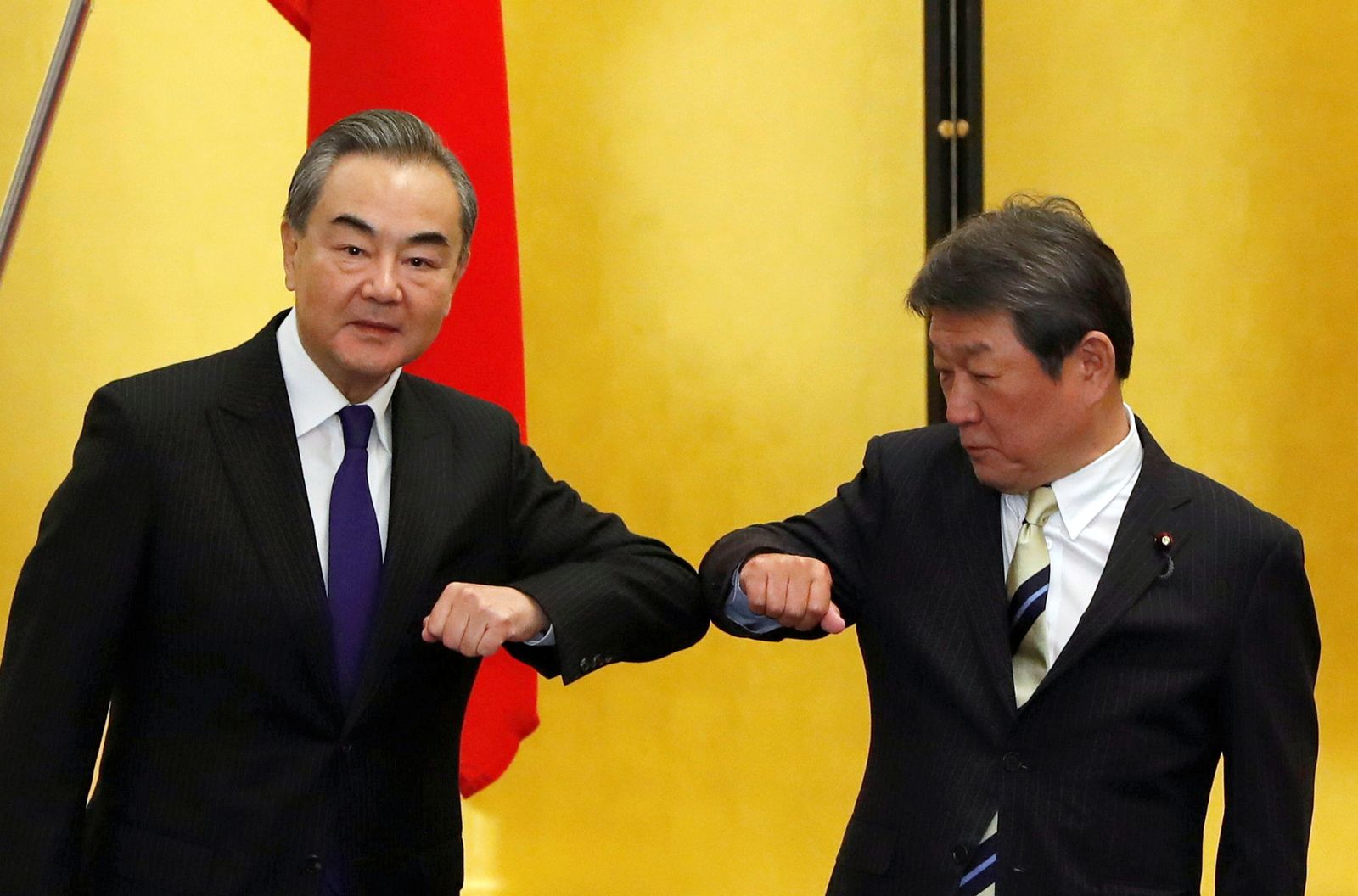 وزيرا الخارجية الياباني توشيميتسو موتيجي (يمين) والصيني وانغ يي خلال لقائهما في طوكيو - 24 نوفمبر 2020 - REUTERS