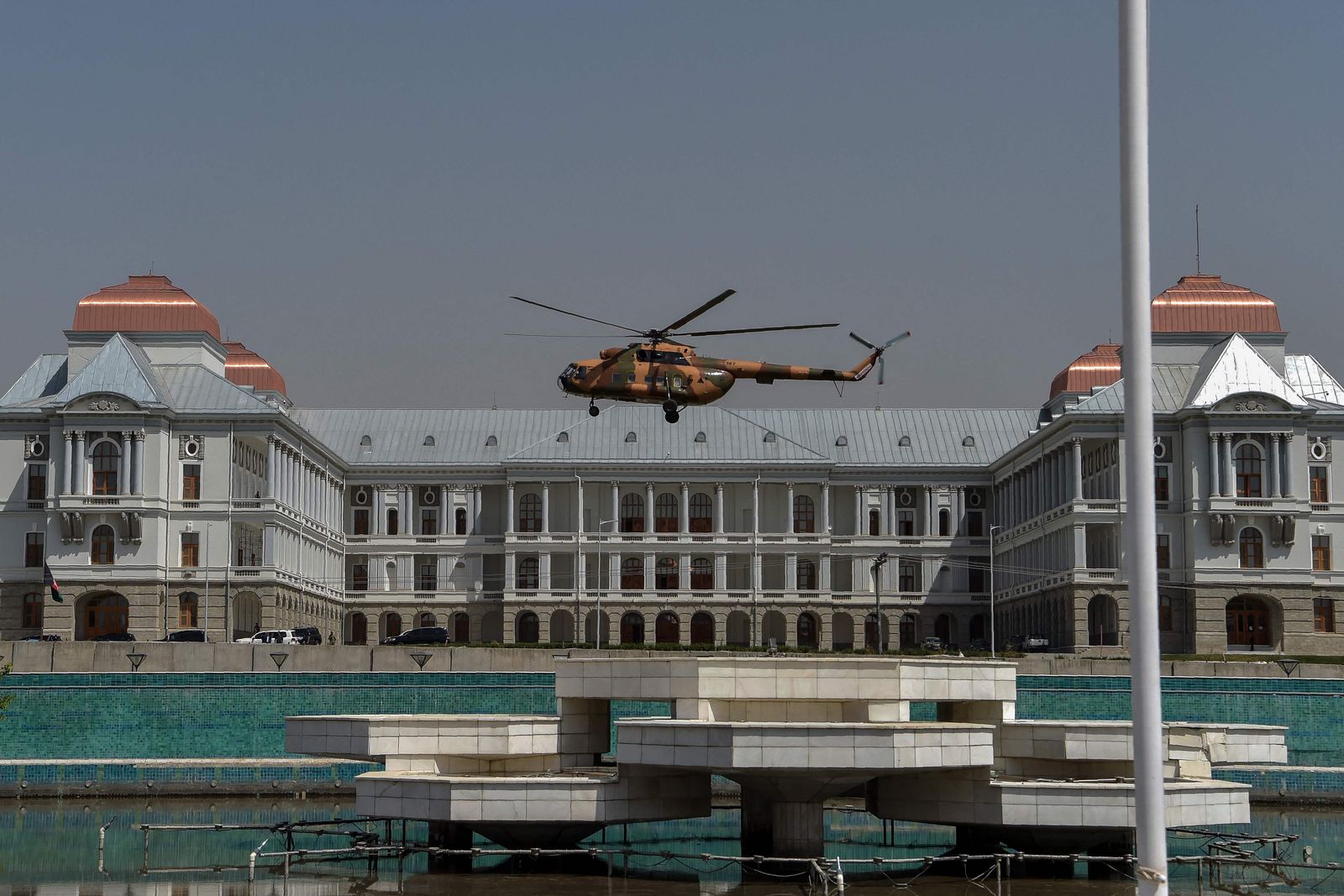 An Afghan Air Force's helicopter rovers near the Afghan Parliament house in Kabul on August 2, 2021. (Photo by WAKIL KOHSAR / AFP) - AFP