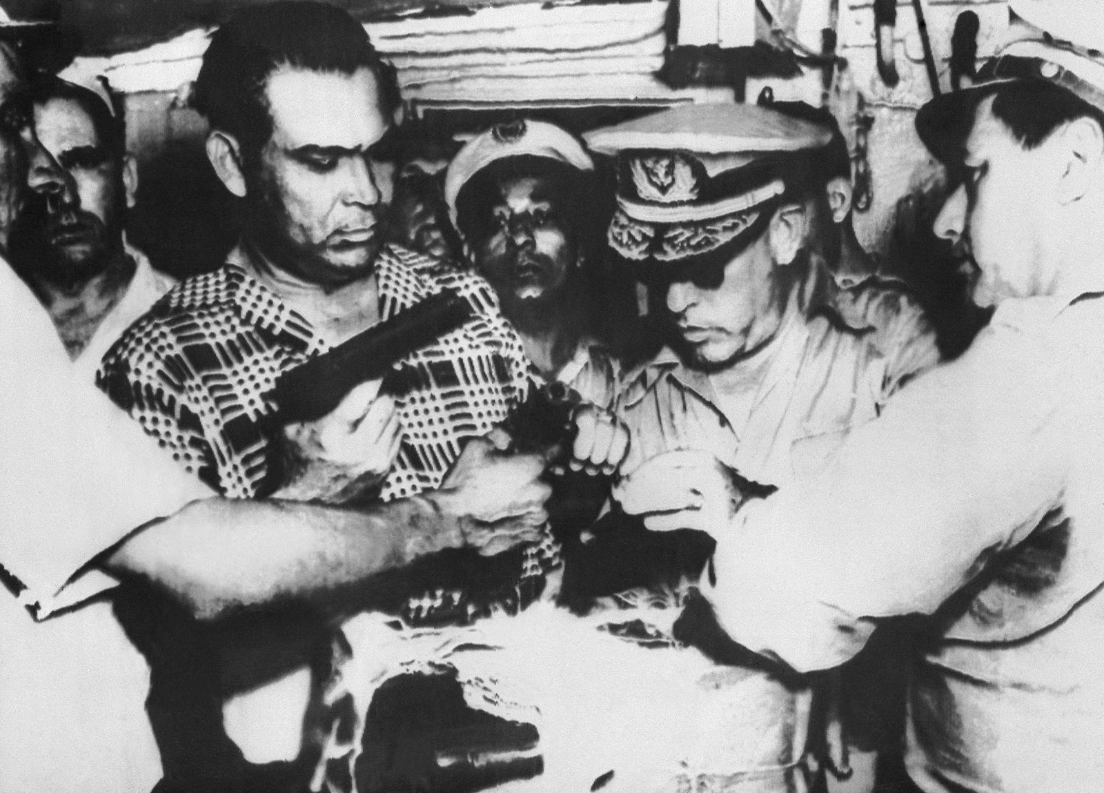 الرئيس الكوبي الراحل فولخينسيو باتيستا (يسار) يعاين أسلحة وذخيرة ضُبطت في هافانا - 26 يوليو 1953 - AFP