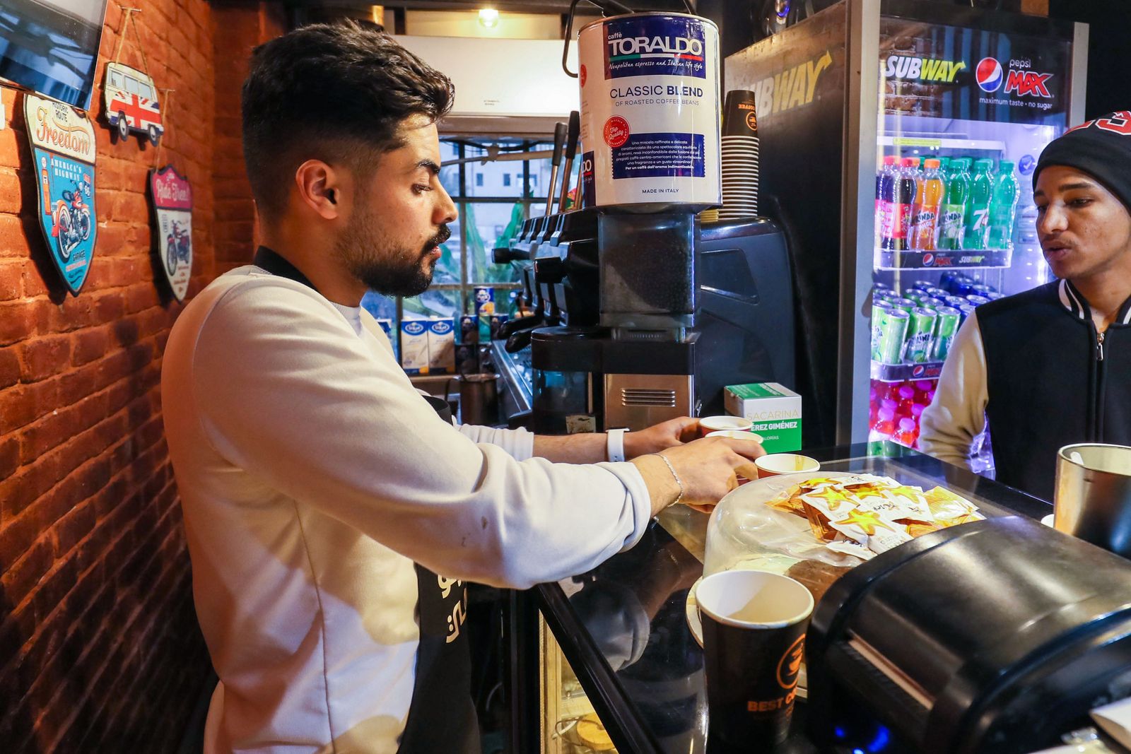 In this picture taken on March 16, 2023, a barista prepares coffee for his customers at a cafe in Tripoli. - Italy left a deep cultural mark on Libya, the only Arab country it colonised: a national love of espresso. But as the fasting month of Ramadan approaches, Libyans are preparing to go without. Throughout the Islamic holy month, which is due to begin this week, observant Muslims are expected to refrain from eating and drinking from dawn to dusk. (Photo by Mahmud TURKIA / AFP) - AFP