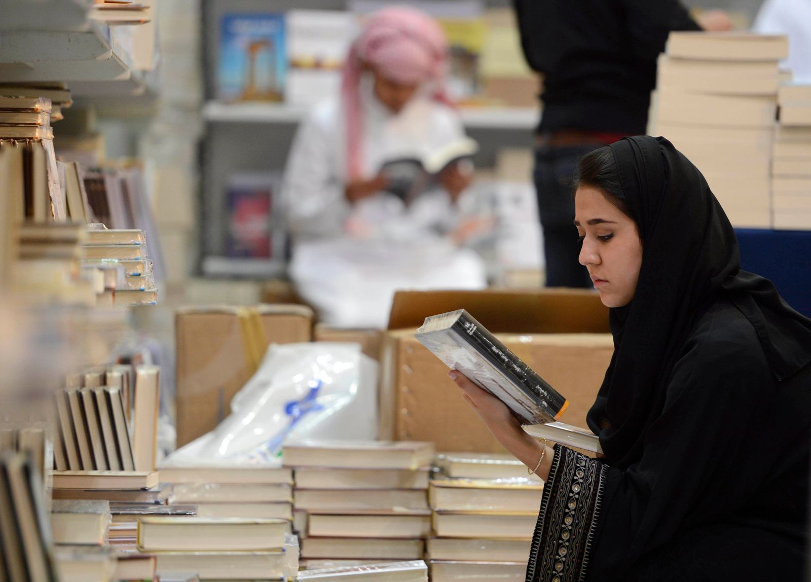 سيدة تنظر إلى كتاب خلال معرض الرياض للكتاب في مركز المعارض الدولي بالعاصمة السعودية الرياض. 9 مارس 2013 - REUTERS