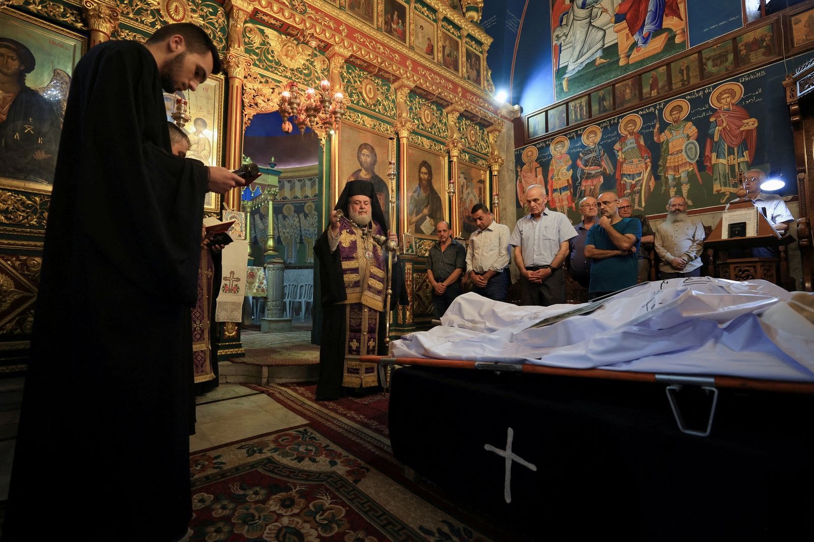 Archbishop Alexios stands in front of the bodies of Palestinian Christians Saad Salama and Foumia Ayyad, who were killed in an Israeli strike on the Holy Family Church, according to medics, as mourners attend their funeral at the Greek Orthodox Saint Porphyrius Church, in Gaza City, July 17, 2025. REUTERS/Dawoud Abu Alkas     TPX IMAGES OF THE DAY